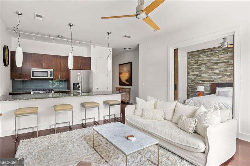 Live in the heart of Inman Park at Grinnell Lofts, where you have a front-row seat to the BeltLine and all the dining, shopping, and green space that make this one of Atlanta's most vibrant neighborhoods. Inside, a sleek contemporary kitchen features high-end Bosch stainless steel appliances, gorgeous granite countertops, and an entertainer's island that flows into the open living and dining space. Floor-to-ceiling windows and a spacious walk-out balcony fill the home with natural light and frame incredible city views. Soaring 10-foot ceilings and beautiful hardwood floors run throughout the main living areas, while cozy Berber carpeting adds warmth in the bedrooms. The primary suite offers a spa-like retreat with a double vanity, relaxing garden tub, oversized tile shower, and a professionally designed closet system for exceptional storage. The second bedroom includes its own generous closet and easy access to the guest bath. Additional comforts include in-unit laundry, abundant storage, and a dedicated covered parking spot. Life at Grinnell Lofts comes with secure keypad entry and access to a rooftop lounge with sweeping city views. Residents also enjoy a sparkling pool and a state-of-the-art fitness center through X3 Sports, complete with modern equipment and a full schedule of group classes. Just outside your door, you can walk or bike to neighborhood favorites like Krog Street Market, Ponce City Market, and Piedmont Park. This home blends style, comfort, and convenience with unmatched access to the BeltLine.