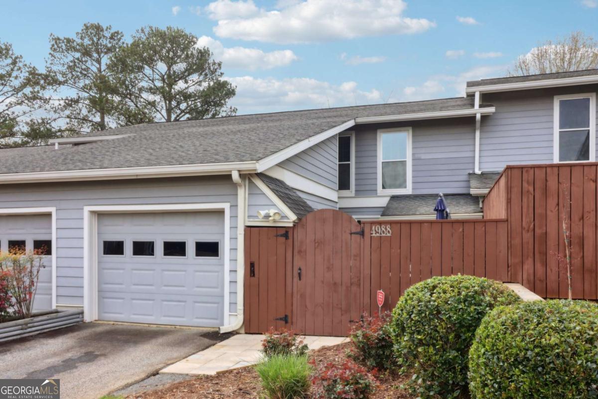Welcome to this charming East Cobb home in excellent school district! This 3 bed, 2 and a half bath condo has been very well-maintained and is move-in ready. One-car garage with surplus storage room. The kitchen features white shaker cabinets, granite countertops, subway tile backsplash, stainless appliances and high-end lighting fixtures. The dining area has plenty of room for everyone and flows seamlessly to the living room, with a board and batten accent wall. Wide-planked engineered hardwoods, a half bath, the laundry room & a reading nook cap off the main level. Up stairs is the primary suite, w/ his and hers closets, & a barn door leading to the ensuite bathroom with granite, & tiled shower. Two additional spacious bedrooms share another full bathroom w/ granite and a tiled shower/tub. Fenced & private front patio with outdoor dining area. Out back, you'll find a fenced area perfect for grilling. The neighborhood pool is just a short walk away. Additional parking in the driveway, one assigned space in front, and guest parking throughout the community.