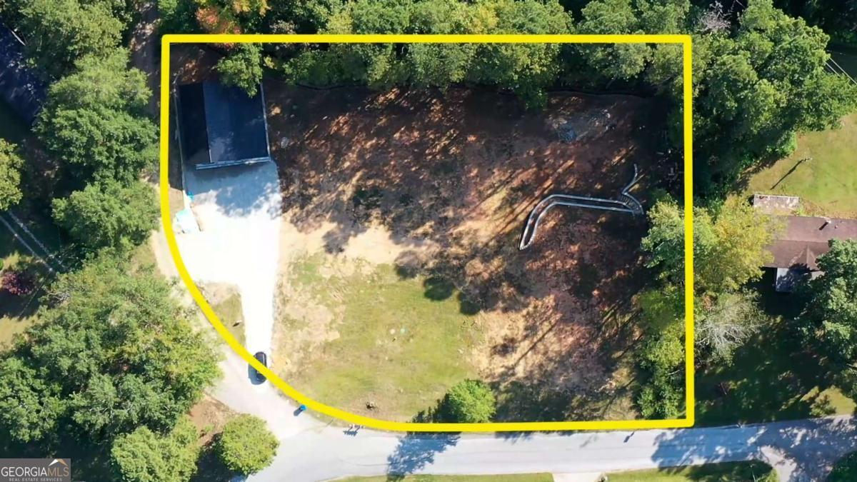 Welcome to 24 Polk Path in Dallas, Georgia. This unique one-acre property offers a rare opportunity for buyers seeking a homesite that is not only spacious but already thoughtfully prepared for construction. The land has been cleared, graded, and equipped with essential infrastructure, making it an ideal foundation for a custom-built residence or the placement of a mobile home. One of the standout features of this property is the newly constructed shop, designed with both functionality and value in mind. The shop is equipped with plumbing and its own water supply and is supported by its own dedicated septic system. The structure is complemented by an impressive 60-foot retaining wall, adding both structural integrity and an attractive finished look to this side of the parcel. The designated house site is equally impressive and ready for immediate development. A newly installed septic system, sized for a three-bedroom, two-bathroom home, is already in place. The house pad sits on an 80-foot double retaining wall that includes carefully designed side steps, creating an appealing and practical foundation for the home. A conveniently located water supply near the pad further enhances the property's readiness for construction. This property combines practical preparation with long-term potential. Whether you are looking to build your dream home from the ground up or place a mobile home on a well-prepared lot, the groundwork has already been done for you. The seller also has receipts, surveys, soil tests, and perc tests available for review, providing full transparency and peace of mind to the buyer. 24 Polk Path presents an excellent opportunity to invest in land that offers both immediate usability and future potential. At a list price of $150,000, this property is a strong value in the growing Dallas area. Schedule a showing today and see firsthand the possibilities this property provides.