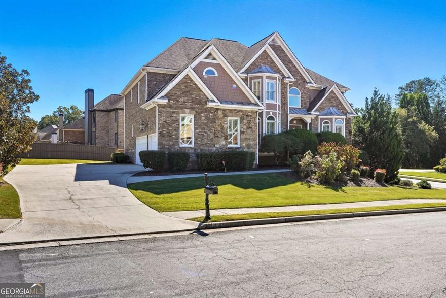 Presenting a stunning executive home in the heart of West Cobb!    This beautifully appointed residence offers 5 bedrooms and 4.5 baths across an open, elegant floor plan. Step through the grand two-story foyer and be greeted by an impressive entrance that sets the tone for the entire home. A formal dining room and executive office flank the entry, leading into the spacious living room with soaring 40-foot ceilings and abundant natural light.    The gourmet kitchen is a true showpiece-complete with a butler's pantry, a large walk-in pantry, and an expansive island that flows seamlessly into the breakfast area and family room, creating the perfect setting for entertaining. The main-level guest suite offers privacy and comfort, ideal for in-laws or visiting guests. All main-level living spaces feature freshly re-stained hardwood floors for a refined touch.    Upstairs, you'll find four bedrooms and three baths, including a luxurious primary suite with a sitting area, spa-like bath, oversized shower, and a massive walk-in closet. With over 4,000 finished square feet plus 1,500 sq. ft. of unfinished basement, there's endless potential to expand or customize. Situated on a coveted corner lot, this home features a 4-car garage - three on the main driveway and a fourth connecting to the unfinished basement. The level and spacious yard offer endless possibilities for outdoor enjoyment and activities.    Perfectly located near top-rated schools, shopping, and dining-this West Cobb gem blends luxury, comfort, and convenience in one remarkable home. This executive home, crafted with 4-sided brick, stands as the original model for the community, showcasing unique and timeless design elements.