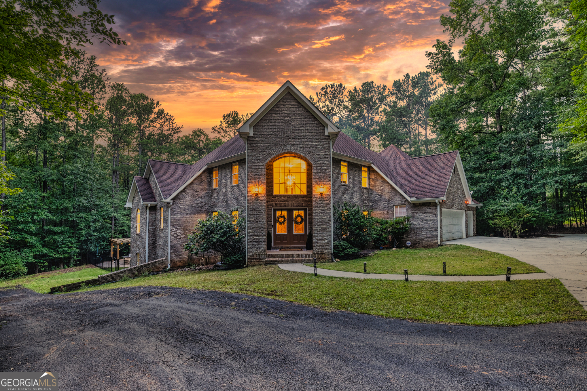 Your Private North Coweta Oasis - Custom Luxury Styled for Outdoor Entertaining Year Round. Welcome to a one-of-a-kind retreat in the sought-after Northgate High School district - a 4 bedroom, 4.5 bath home set on a private, wooded 5-acre tract. From the moment you turn onto the winding drive, you'll know this is something special. Designed from the ground up - architectural plans convey - this low maintenance, four-side brick home offers a lifestyle that's as functional as it is unforgettable. Your front door opens to a soaring Foyer bisecting the formal Living Room and Dining Room, and then flowing into a large Family Room centered on a fireplace. The Kitchen features custom oak cabinets with under-cabinet lighting and stone countertops. The Breakfast Room and Family Room offer access to the screen porch and a grilling deck near the Kitchen. The Primary Suite is on the main level, featuring a spa-style bath with dual vanities, a jetted tub, and a separate shower. Upstairs, you'll find three more Bedrooms plus a huge Bonus Room - perfect for work, play, or guests. Step outside and discover a backyard oasis designed by J&M Pools - a heated and cooled PebbleTech saltwater pool with waterfall, sun shelf with bubblers and loungers, and dazzling LED lighting. The KoolDeck concrete patio, fire pit, and Bullfrog hot tub make entertaining effortless, while the Outdoor Kitchen shaded by an arbor sets the scene for memorable gatherings. Enjoy a screen porch for relaxing mornings, a grilling deck for summer feasts, and the convenience of a new terrace-level Full Bath adjacent to the pool. Three garages on the kitchen level plus a boat garage/shop on the terrace level (with concrete drive access) ensure space for every hobby. Spray foam insulation and newer HVAC units offer energy efficiency. All this is just minutes from Interstate 85 and the 300-acre BT Brown Reservoir, offering fishing and kayaking among quiet natural beauty. With thoughtful design at every turn, this is the home you've been waiting for - a truly custom home where every day feels like a getaway. Schedule your tour and experience the lifestyle for yourself.