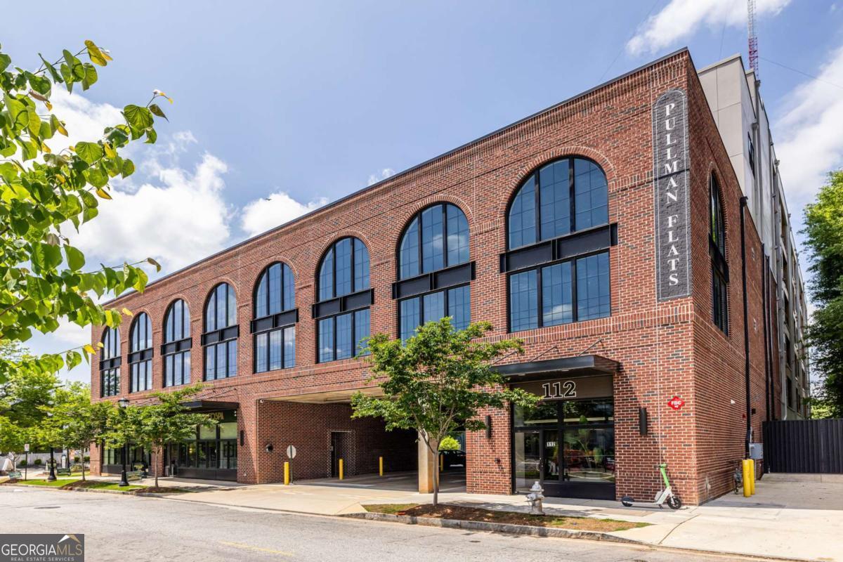 Welcome to contemporary urban living in the heart of Kirkwood! This nearly new, beautifully appointed 2-bedroom, 2-bathroom 5th floor corner condo offers the perfect blend of style, space, and convenience, positioned directly across from the vibrant Pullman Yards development. Step into an open-concept masterpiece featuring soaring 10-foot ceilings and an expansive living, dining, and kitchen area that maximizes both form and function. The gourmet kitchen showcases sleek white cabinetry, elegant quartz countertops with waterfall detailing, premium stainless steel appliances, and a generous breakfast bar island-perfect for entertaining or everyday dining.. Floor-to-ceiling windows flood the space with natural light and offer picturesque views of the adjacent soccer field. The primary suite serves as your personal sanctuary, complete with a spa-like ensuite bathroom featuring dual vanities, an oversized walk-in shower, and a private water closet. The secondary bedroom includes its own full bathroom with granite countertops and a tub/shower combination. The unit includes one assigned parking space Residents enjoy access to premium amenities including a fitness center, rooftop deck with grilling stations and games area, an outdoor terrace with fireplace, and a convenient dog spa facility. This prime Kirkwood location puts you steps away from parks, diverse dining options, shopping, MARTA access, and the exciting developments at Pullman Yards. The neighborhood perfectly balances urban amenities with community charm.
