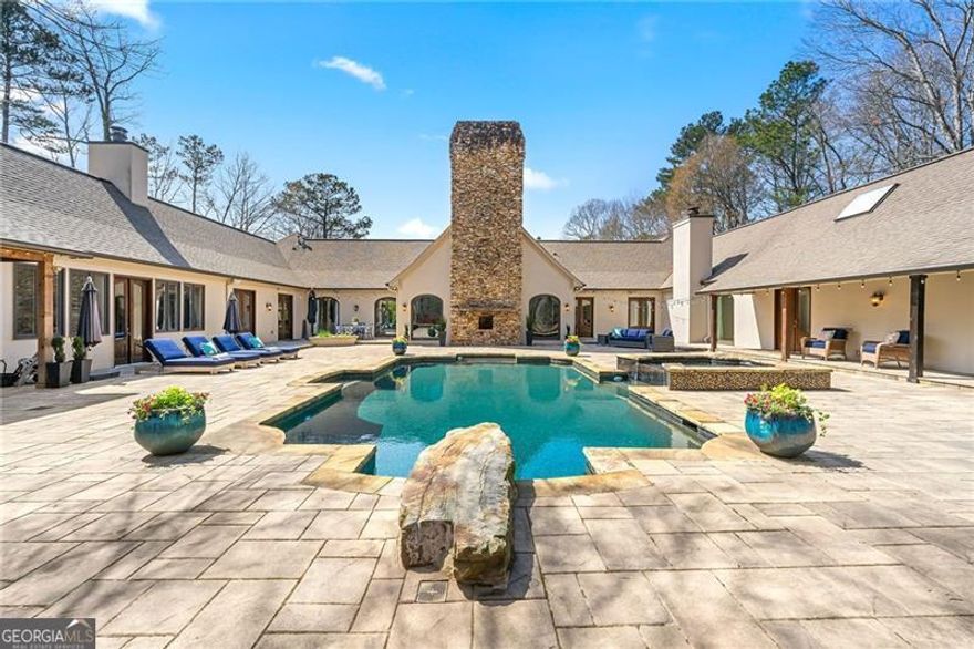 Gated sanctuary wrapped within 4.5+/- acres in Buckhead! Wind your way through a tranquil, wooded property to an elevated and secluded house. Embodiment of one floor designed living, the house orients each oversized and light-filled living space with direct access and views to centralized outdoor space featuring: 4500 sqft patio, outside kitchen with pizza oven, pool, pool house, hot tub and gazebo. Enter the central wing through grand porte-cochere into a dramatic foyer and breathtaking living room with peaked 26 ft tongue/groove ceiling and majestic stone fireplace. Entertainer's dream wing features a completely renovated kitchen with custom oak cabinetry, Calcutta Gold quartz island and matching countertops, two dishwashers, Wolf range, Subzero refrigerator and two full size wine refrigerators. This wing extends through the keeping room, with fireplace, into the peaked sunroom. Accordion doors then link the outdoor kitchen and external living room space to the entertainment wing. Expansive primary suite wing of the house includes private access to secluded outdoor retreat with fire feature. Renovated primary bath with dual vanities, separate tub and shower and large walk-in closet. Every bedroom boasts renovated ensuite bathrooms with pool house available as an optional nanny suite with separate entrance and full kitchen. The house uniquely combines indoor/outdoor living with the essence of the unparalleled property. Move in ready with over a million dollars of renovations.