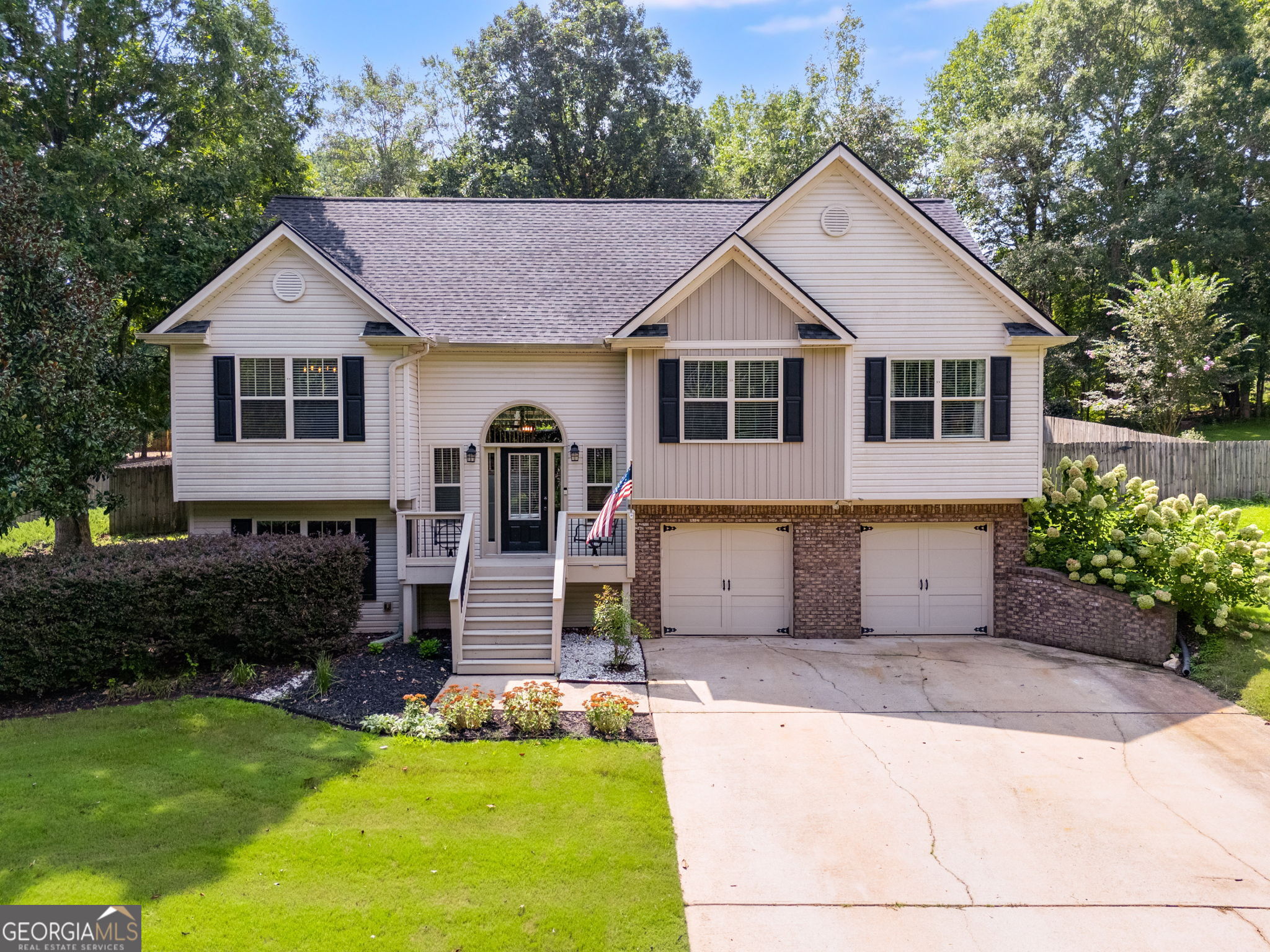Welcome to 280 Elk Drive in Temple! This spacious home in the South Paulding school district offers a great combination of comfort and flexibility. The exterior features a wooden privacy fence, a large entertainment deck, and an additional outbuilding for storage or hobbies. The yard is beautifully landscaped with lush Tiftway Bermuda grass, established flower and shrub beds, and irrigation to keep everything thriving. Inside, a dramatic curved staircase sets the tone for the main level, which features fresh interior paint, updated on-trend light fixtures, and laminate hardwood floors in the living room, dining area, and bedrooms. The living room is anchored by a cozy fireplace and built-in bookcase along the interior wall, adding both charm and functionality. The lower level offers a generously sized bedroom, a full bathroom, and an expansive flex space - with private access from both the front entry and the garage - creating opportunities for guests, separate living arrangements, or a home office. The garage also includes an additional storage room for added convenience. Enjoy nearby dining in Downtown Temple, abundant local parks, shopping in Villa Rica and Dallas, plus easy access to I-20 for commuting.