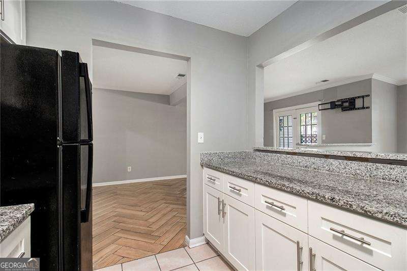 Lease Purchase Available! This beautifully renovated ground-floor end unit is flooded with natural light and offers easy access to parking. The entrance foyer leads into an eat-in kitchen that features a breakfast area, solid surface countertops, abundant workspace, and stainless steel appliances. The kitchen opens directly to the living room, creating a spacious and connected feel. A large walk-in flex room can serve as a home office or a walk-in pantry, ideal for avid cooks. Includes a full-size washer and dryer. Double French doors lead to a private patio. There is also a separate dining room. Renovated bathrooms feature modern cabinetry and lighting, with spa-like walk-in showers and ADA bars for accessibility. Gas is included in the HOA, so it's provided to the tenant at no extra cost. Electricity is the only utility the tenant has to pay. Great close-in location in the heart of Tucker, just a skip from I-285 and off Lawrenceville Highway.