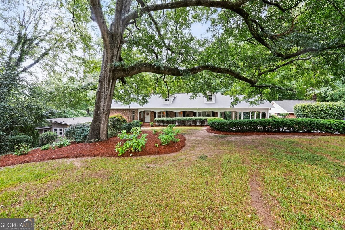 WOW! WOW! WOW! This home honestly has it all including an adorable guest cottage, rent the cottage to help pay your mortgage or use it as a home office. First of all you will love the location just a brief walk to Ingleside Village for shopping, coffee, pizza or music and drinks at Society Garden. This home is tucked away on a large wooded lot and sits back from the road. Each room in this house seems to have unique architectural details. You will absolutely love the huge great room on the main level that is both a formal living room and dining room with a stunning marble fireplace and big windows overlooking the private, wooded property. The primary bedroom has an ensuite bath and large closet. There are 3 other generously sized bedrooms, another full bath and a rustic wood paneled office on this level. The lower level boasts a huge family room with brand new carpet, a masonry fireplace and a perfect bar area for entertaining. The kitchen has lots of cabinets, solid surface counters and comes with a full package of appliances. There is a breakfast area and a keeping room with sliders leading out to the picture perfect back yard. You will be enchanted with the cafe lights that are strung above the brick patio and deck. This backyard is so private you will think you're out in the country but you're actually minutes from downtown and I-75.