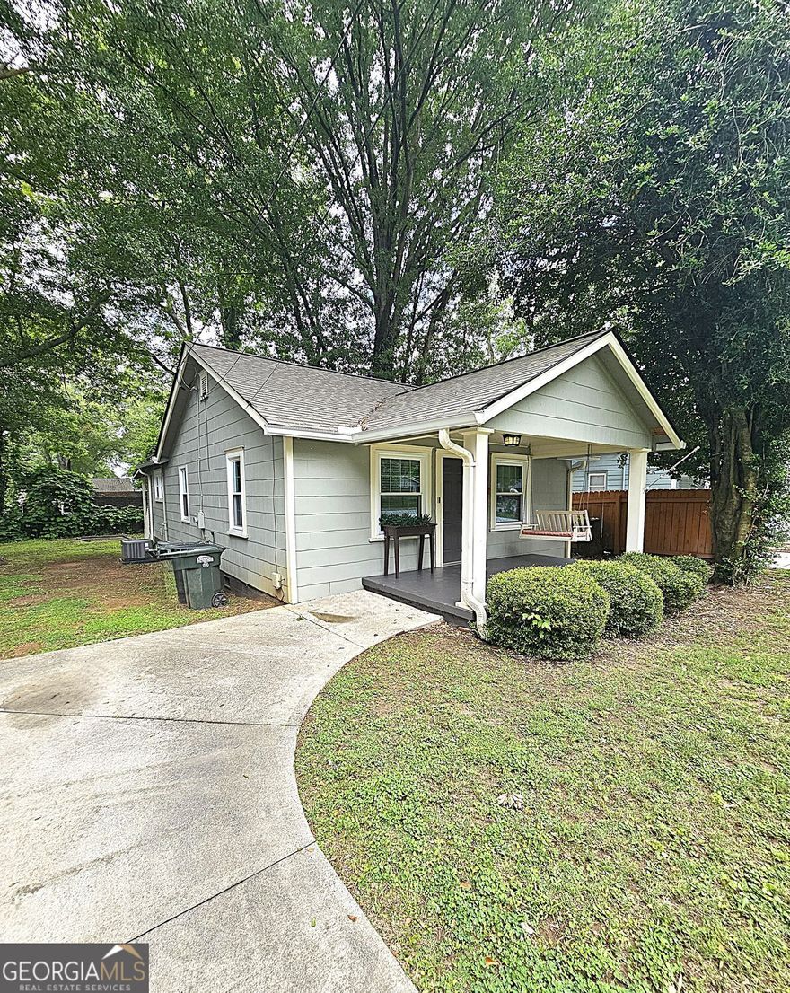 This cutie sits in an area that puts you minutes from the square of historic Marietta and on a street of neighbors who are a community and friends. Beautiful and mature trees frame the house. This open concept home with lots of windows inviting the natural light from outside into the home. Kitchen has stainless steel appliances and hood vent, granite counters and brand new luxury plank flooring. 2 bedrooms each having their own bathroom. The primary bedroom has brand new carpeting. The remainder of home has luxury plank flooring. Owner will leave the stacked washer/dryer combo. A fresh new coat of paint on the interior, upgraded windows, a new gas hot water heater and brand new heating and cooling allows you to move right in and enjoy yourself, spending your money on home decor or entertaining your guests. Enjoy the cute front porch swing with morning coffee or after work, and there is also a wonderful back porch that could easily be screened, if desired, for a more private outdoor experience. Level flat yard and a concrete pad which is perfect for fire-pit or a portable shed. Concrete parking area. Home warranty provided to purchaser. Come on home!