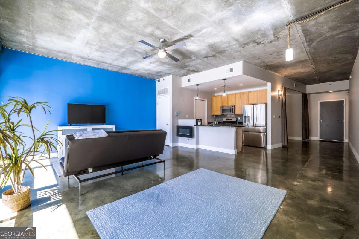 Centrally located in Midtown's Tech Square, convenient to all your needs, this home features 10 foot ceilings and polished cement floors throughout. The kitchen with stainless steel appliances and granite counters has a laundry room with plenty of shelving for storage. The open floor plan is flexible with room for separate sun-soaked living and dining areas, plus a separate space for a home office. The bedroom features a custom closet with wall of mirrors. An updated bath features a walk-in shower with custom tile work. The unit faces south and has a large balcony with heaters, allowing you to enjoy your outdoor evenings year-round. Your parking space (#60) is already equipped with a charging station for your EV, too! Amenities include 24/7 concierge, business center, fitness center, club room, fireside lounge and rooftop pool.