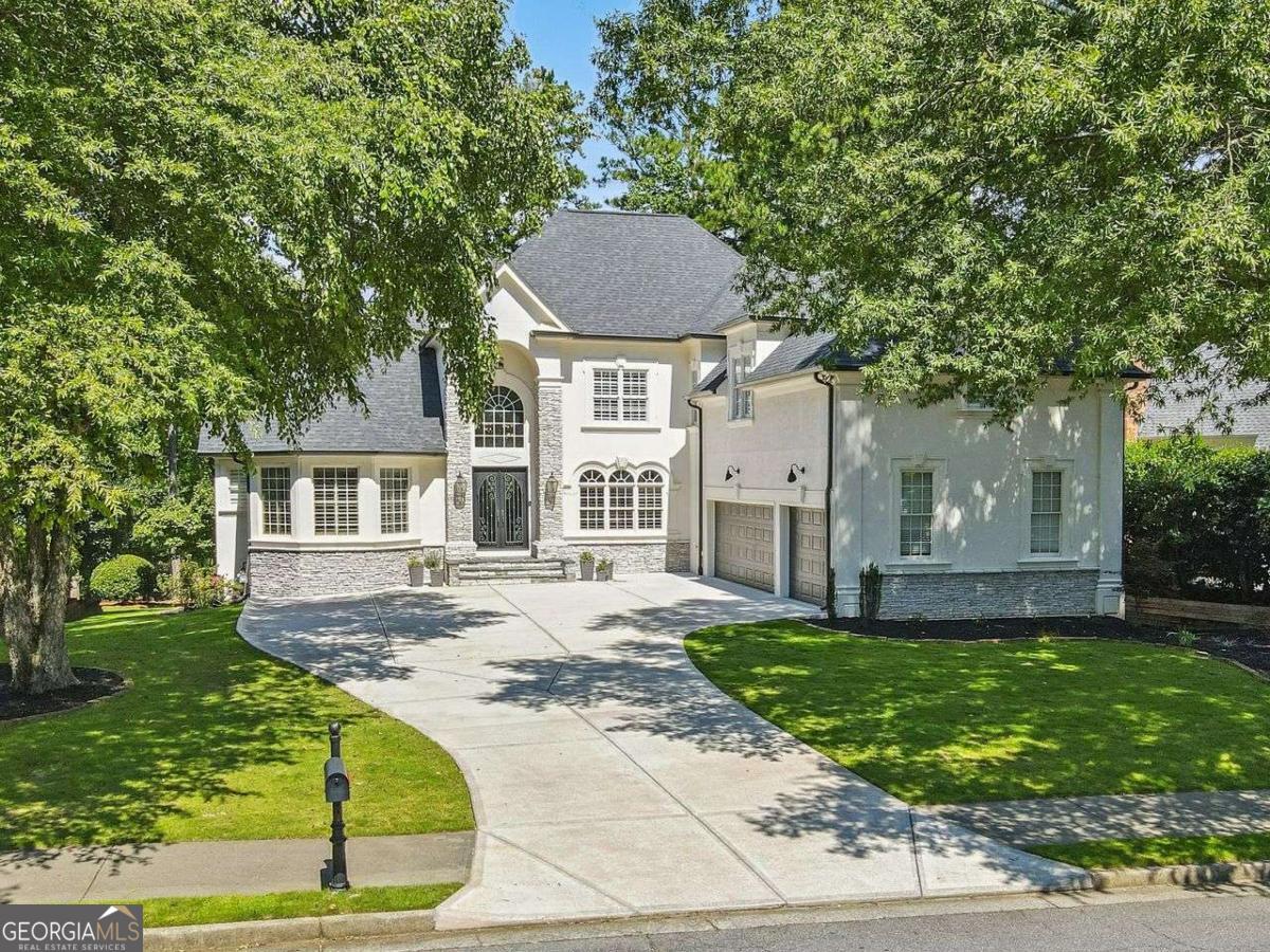 Welcome to this exquisite five-bedroom, four-and-a-half-bath home perfectly positioned on the 6th hole of the Iron Horse Golf Club in the highly desirable Alpharetta/Milton area within the gated community of Crooked Creek. Recently refreshed with new interior and exterior paint, this residence blends timeless elegance with modern upgrades. The exterior features newly added stonework integrated into the stucco facade, enhancing curb appeal and architectural character. Step inside to discover updated lighting throughout and a thoughtfully renovated interior that exudes luxury. The main-level primary suite and bath are a true retreat featuring custom closets and recently renovated bath including gold-finished fixtures, a freestanding soaking tub, and a custom shower that rivals any spa. The gourmet kitchen is a chef's dream, boasting a Sub-Zero refrigerator, an oversized island with a five-burner cooktop, a wine fridge, and a cozy keeping room perfect for casual gatherings around the stack stone gas fireplace. Upstairs includes three spacious bedrooms, one with a private on suite bath. The newly updated basement offers fresh flooring and versatile space for recreation, fitness, or relaxation. Unwind in your private sauna or step outside to enjoy the hot tub and fire pit, both overlooking the lush fairways for serene evenings under the stars. The home also includes new gutters with guards for low-maintenance living. Beyond the home, the community offers resort-style amenities including a 24-hour gated entrance, direct access to the golf course, 10 tennis courts, 4 pickleball courts, a basketball court, a junior Olympic pool, splash pad, waterslide, and a playground. Located just minutes from Avalon and Halcyon, you'll enjoy premier shopping, dining, and entertainment options right at your fingertips. This property is the perfect blend of luxury, comfort, and convenience.