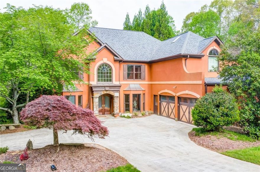 Mediterranean-inspired estate on a cul-de-sac with a Roswell address and Cherokee County taxes. This nearly one-acre retreat is situated in the Foxhall community, which offers swimming, tennis, and playground, making it perfect for those seeking a vibrant yet peaceful lifestyle.  The home's stunning architectural details set the tone from the moment you arrive. Enter a grand foyer leading to an open-concept living area, where natural light floods through the windows, accentuating the high ceilings and stunning finishes. At the center of the home lies the well-equipped kitchen, featuring radiant heated floors that foster a warm atmosphere and equipped with modern high-end appliances (2021) for effortless entertaining. The two-story living room features a cozy fireplace flanked by floor-to-ceiling built-in bookcases. A full guest suite on the main level provides flexibility for visitors or multi-generational living. Upstairs, the oversized primary suite has tray ceilings and an ensuite bath with a whirlpool tub, separate shower, dual vanities, and three walk-in closets. Two secondary bedrooms share a bath, and a fourth has an ensuite bath. The luxury continues with both main and upper level laundry rooms for convenience. Step outside to your professionally hardscaped backyard oasis, where a cascading waterfall and tranquil koi pond create a private sanctuary. To ensure year-round comfort, every detail has been thoughtfully designed, including a whole-house water filtration system and a new HVAC system (2021). Whether sipping morning coffee on the patio or hosting an evening gathering, this outdoor retreat is unique. This home invites you to experience luxury living in one of Roswell's most sought-after communities.