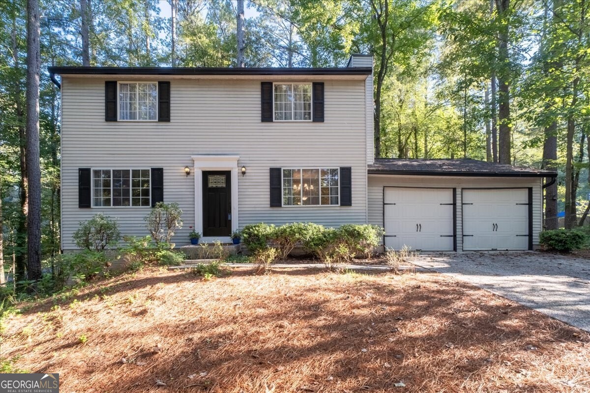 Beautiful 2-story traditional home on a full basement in a peaceful, family-friendly neighborhood in East Cobb!! This delightful 4-bedroom 2.5-bath is perfectly situated on a spacious low maintenance, wooded cul-de-sac adjacent corner lot in the sought-after North Landing subdivision. The main level features a family room and a separate living room with a gas log brick fireplace, a bright eat-in kitchen with a pantry, half bath, and dining room with a barn door, making it an optional home office/bonus room. The 2-car kitchen-level garage makes for easy living and can accommodate Trucks and SUVs. Upstairs, the primary suite includes a private en-suite bathroom with a shower, three additional bedrooms, and another full bathroom. The unfinished basement with interior and exterior access provides laundry space, abundant storage, and the potential to be finished for additional living or recreational space. Enjoy outdoor living on the covered porch and large deck overlooking the natural backyard where deer and birds are regular visitors! Roof and gutters replaced in 2021! Many updates, including fresh interior paint and laminate wood flooring. The HVAC was serviced in June. The home has a termite bond. Neighborhood amenities (optional) include a community pool, lake, tennis/pickleball courts, and disc golf. Location is just minutes to Kell and Lassiter High Schools, shopping, downtown Woodstock, Marietta, and multiple dining options. Home is move-in ready!