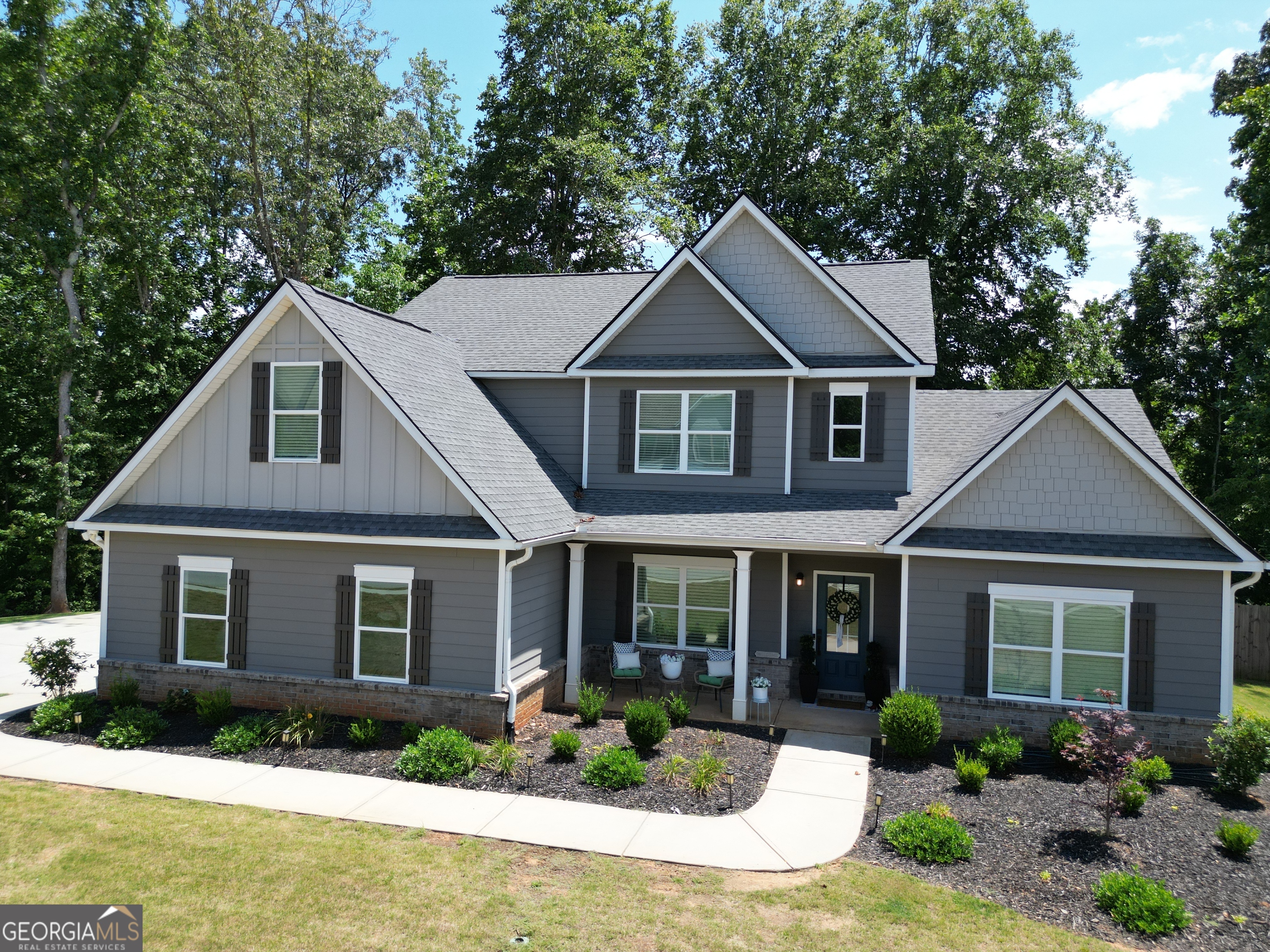 This stunning 4-bedroom, 3.5-bath home sits on over half an acre, corner lot with a large, level driveway. The open-concept layout features a bright great room with a board and batten accent wall, brick fireplace, and tons of natural light, flowing into a chef's kitchen with stainless steel appliances, a large island, and granite countertops. You'll love the bonus room off of the kitchen perfect for an office or convert to your dream scullery that will be sure to impress your guests. The main-level primary suite boasts a spa-like bath, dual vanities, a soaking tub, and a custom walk-in closet. Upstairs, you'll find three additional bedrooms, 2 full bath, and a versatile loft area perfect for play or media room. Freshly painted with custom updates, a formal dining room, fenced backyard, and ample storage, this home is minutes from Lake Lanier, shopping, and dining in Flowery Branch. A must-see!