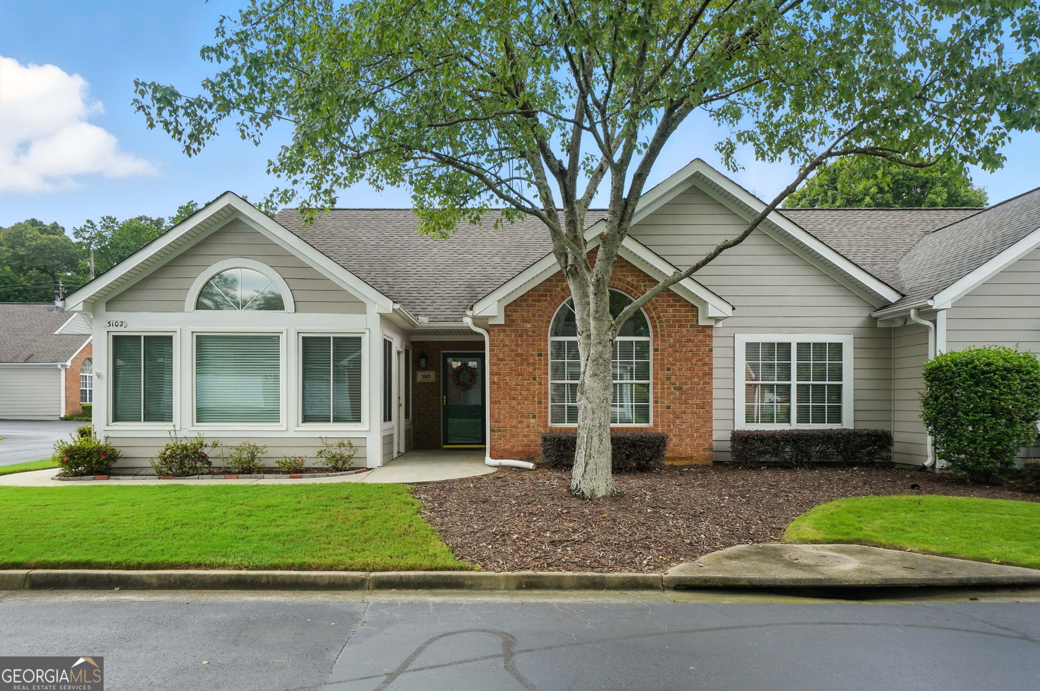 Located in the Alpharetta Garden District, this ranch condo offers low-maintenance living less than 2 miles from Downtown Alpharetta! This 3 bedroom, 2 bath home offers an open concept floor plan with vaulted ceilings throughout. The updated kitchen features granite counters, white cabinets, and white appliances including a new dishwasher, microwave, & refrigerator. The kitchen flows seamlessly into the dining room, and all of this overlooks the inviting family room with a gas fireplace. Enjoy your morning coffee while sitting in your vaulted sunroom with upgraded windows allowing so much natural light to flow inside. The master bedroom is a true retreat which offers vaulted ceilings, a bathroom with dual vanities, walk-in closet, and a new walk-in tub. There are 2 generously-sized bedrooms with vaulted ceilings located on the opposite side of the master bedroom, and they share a full bath. The two car garage is large enough for your cars and storage, and this garage has been recently updated with an epoxy floor coating! Some additional upgrades include fresh/neutral paint, a new garage door, a sliding glass door for the sunroom with built-in blinds, newer carpet in the bedrooms, & and a new water heater. The Orchards at Hopewell is an active community with a pool & a clubhouse which features a meeting room, kitchen, library & fitness center. You'll be sure to meet new friends at their social events such as playing canasta or bridge, attending the community cook-out, or at the monthly ladies/men's luncheons. And the location of this ranch condo inside the community is ideal - just a short distance from the pool/clubhouse, lots of shady trees nearby, and it's tucked on the side where there's no road noise. It has been meticulously-maintained where pride in ownership definitely shows! Honestly a rare find!