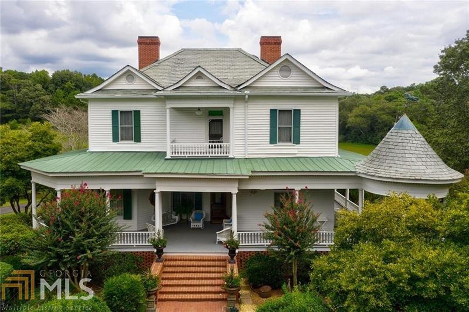 Any day at the farm is truly an experience on this 68 acre estate. Start your morning with breakfast in the gazebo overlooking the lush green acreage. Listen to the babbling fish pond & overlook the stocked fish pond w/dock, or if you prefer, take a walk down to the stables & grab your horse & enjoy trails surrounding the property. Lunch could be served at the 1800 rustic log cabin, a stones throw from the main house or near the Alcovy rivers edge.This property is known for plenty of wildlife especially large Bucks roaming the property. The Circa 1880 Colonial Victorian main home was purchased in Monticello & was moved & was preserved on the property. The setting with mature magnolias and fruit trees is magnificent. The home boasts 12 foot high ceilings on main, heart of pine flooring, & oversized bedrooms. Roof is slate w/attached gazebo. Home features 9 FP, ornate parlor stove, and unique antique lighting that all come with a story. Owners have all the history of the home. Property has a three bedroom caretaker's ranch, 2 car garage/equipment shed, large oak barn & 1800's rustic log cabin guesthouse. Plenty of room for the whole family & plenty of space to build other residences on the property.