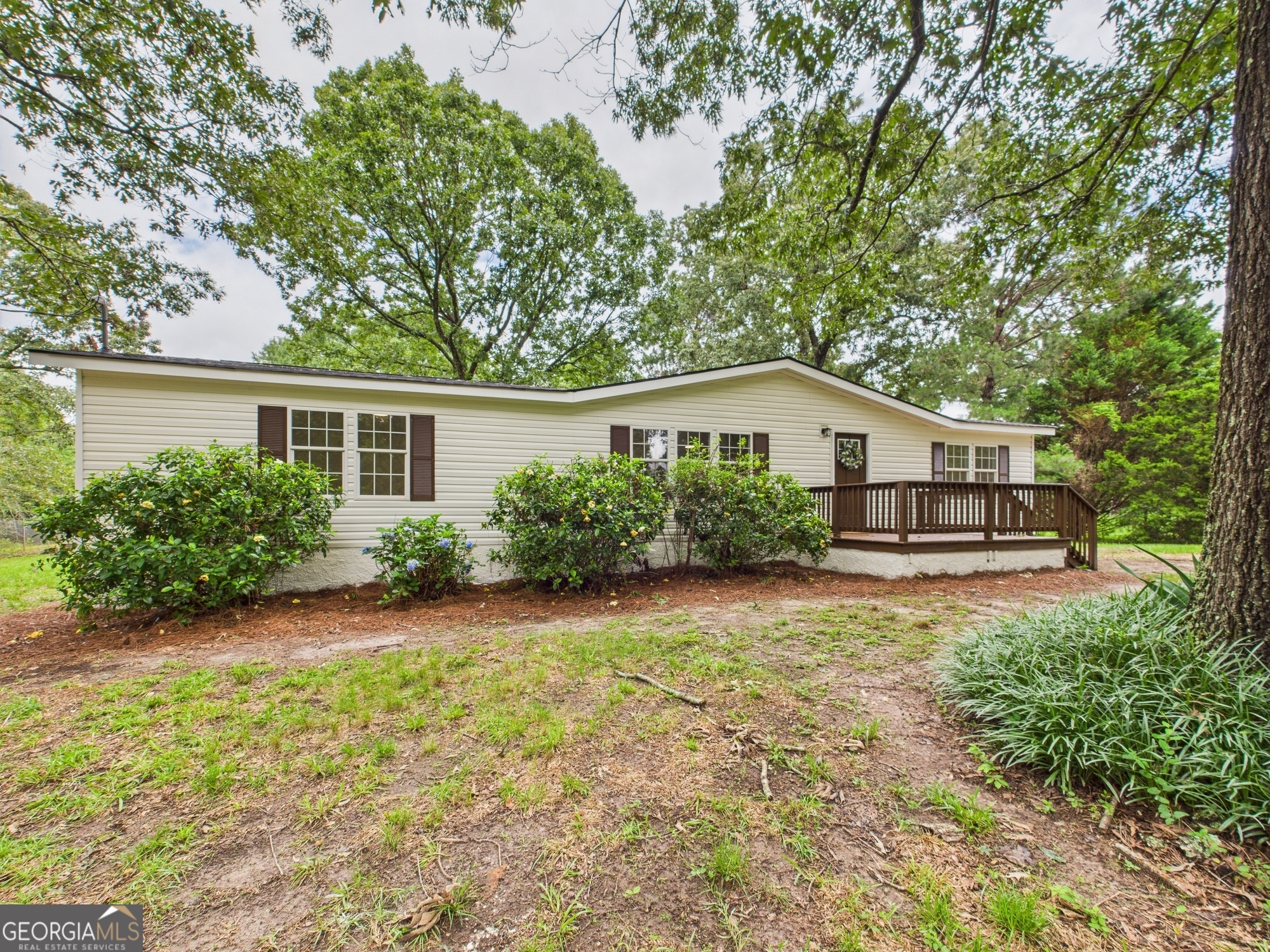 Welcome to your private retreat in beautiful Peach County! Nestled at the end of a long, private driveway, this updated 3 bedroom, 2 bathroom mobile home sits on a generous 10-acre property-offering the perfect balance of peaceful country living with quick access to town amenities. Inside, you'll find a spacious open-concept layout featuring a large living area and a kitchen loaded with cabinet and counter space-ideal for family meals or entertaining guests. The master suite is oversized and inviting, complete with a soaking tub, separate shower, and double vanity. Updated touches throughout give the home a fresh, modern feel, while front and back porches invite you to relax and enjoy the quiet, natural surroundings. This smart home comes with a Smart lock and Amazon Kitchen Tablet! Whether you're dreaming of a mini farm, space to explore, or just want some privacy without being too far from shopping, dining, and schools-this property checks all the boxes. Don't miss this rare find in Peach County!