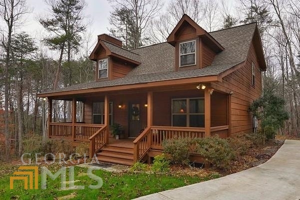 Open-concept rustic cabin with rocking chair front porch! You'll love the great room fireplace with stone soaring to the vaulted ceiling! Enjoy the perfect kitchen with an island, granite countertops, stainless steel appliances, and lots of seating. Bedrooms boast walk-in closets with wood shelving. Large loft for additional entertaining space. Level concrete driveway, gentle terrain, and easy to get to! Long-range seasonal view from large deck. You'll love this luxury gated mountain community with picturesque lake, hiking trails, waterfalls, and 10-site campground.