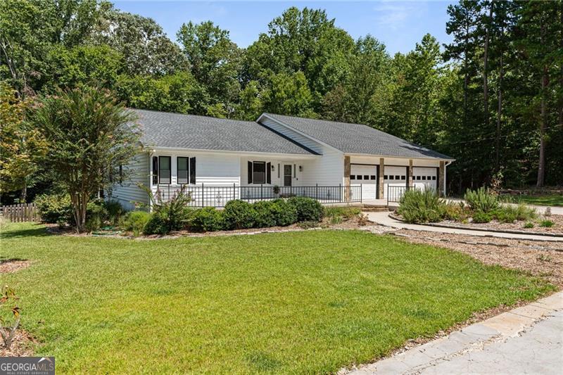 This spectacular ranch proves you really can have it all-style, space, privacy, and Lake Lanier living without the HOA drama (because who needs a committee telling you where to park your boat?). Fully renovated and move-in ready, it even comes with all appliances-so instead of waiting for a Home Depot delivery, you can head straight to planning your first boat day. Walk to Bald Ridge Campground or zip 3 miles to Tidwell Park & Boat Launch and slide right into South Lake Lanier. With parking for your boat, RV, jet skis, and every other oversized toy you've collected, weekends practically throw themselves a party. Speaking of parties-the outdoor living here is begging for string lights, good music, and a group chat titled Patio Vibes Only. Or, if you prefer a quieter scene, the oversized sunroom is ideal for sipping coffee...or cocktails...while you spy on the wildlife wandering past your fenced backyard. Inside, the open floor plan brings the drama (the good kind) with soaring ceilings and custom finishes. The kitchen is so big it could double as the set of a cooking show, complete with quartz countertops, stainless steel appliances, custom cabinetry, and an island large enough to host a charcuterie spread that could feed all of Forsyth County. The main-level primary suite is basically a private spa-with its own fireplace and a marble walk-in shower featuring dual shower heads (yes, dual, because one is not enough). Downstairs, the finished terrace level is the ultimate hangout: a wet bar, office, massive media room, and a private suite with a full bathroom. The terrace level has its own entrance from the garage, and it can double as a standalone apartment: Translation: perfect for in-laws, adult kids, or your new side hustle as a landlord. With a 4-year-old roof and gutters, a 4-year-old deck, a newer septic system, and a laundry list of upgrades, you'll have more time for lake life and less time calling contractors. All this, just minutes from GA-400, the new Cumming City Center, Northside Forsyth Hospital, shopping, and the North Georgia Mountains. Facing east with Corps access from the backyard, 4050 Vintage Court isn't just a house-it's your new headquarters for boating, brunching, and unapologetic relaxing.