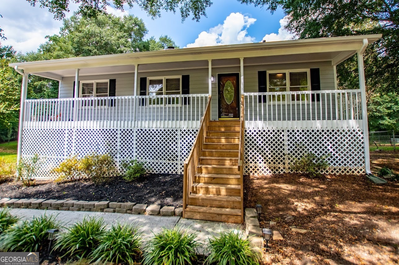 Charming 3-bedroom, 2-bath ranch home on 2.1 beautiful acres with a peaceful creek running along the property. This home features a spacious living room with a cozy fireplace, a bright kitchen with solid-surface countertops and stainless steel appliances, and a brand-new deck overlooking the private backyard. The inviting country front porch is perfect for relaxing evenings. Additional highlights include an unfinished basement offering plenty of storage or expansion potential, plus a convenient drive-under garage. Enjoy the perfect blend of comfort, privacy, and country living just minutes from town.