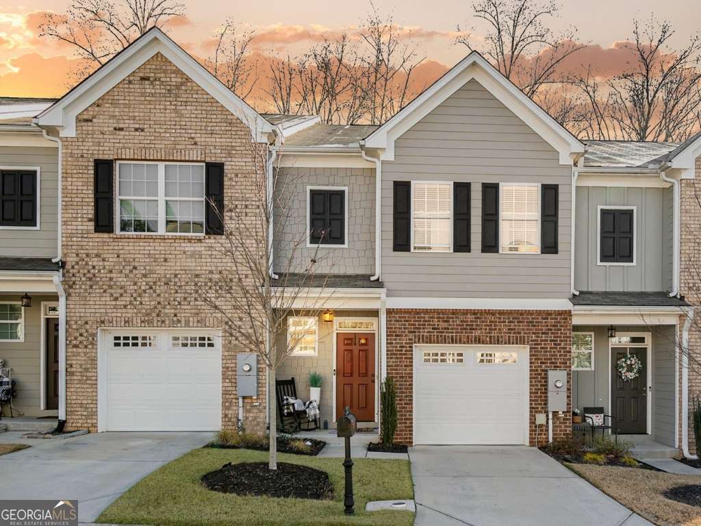 Modern Townhome just a short walk from the shores of Lake Lanier! Step inside to discover an open-concept layout featuring a bright living room that flows seamlessly into the kitchen and dining area. The kitchen boasts clean white cabinetry, granite countertops, stainless steel appliances, and a breakfast bar. Upstairs, you'll find a perfect roommate-friendly layout with three spacious bedrooms, including a primary suite with an ensuite bath and a large closet. Two secondary bedrooms share a hall bathroom. Convenient laundry is located on the upper level. The unfinished basement offers a blank slate for flex space, gym, or media room. Step out onto the private back deck to unwind or enjoy a meal outdoors. The single-car garage provides added convenience and storage. Enjoy lake amenities less than a mile away at Lanier Point Park with a boat ramp, ballfields & picnic pavilion. Located in the Gainesville High School District. With the charm of lakeside living and easy access to dining, shopping, and outdoor recreation, this property offers the perfect blend of comfort and location.