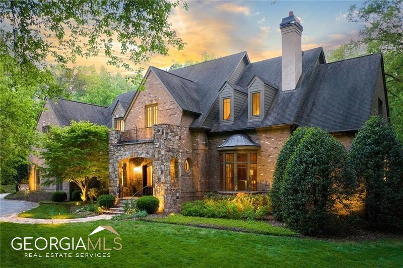 Welcome home to this gated brick and stone Harrison Design custom estate built in 2007 on 2+/- acres. This exceptional masterpiece showcases unparalleled finishes and remarkable architectural elements that will leave you in awe. Upon entry, be prepared to be greeted by a stunning two-story foyer, boasting a cathedral ceiling and stunning ironwork on the staircase. Moving into the fireside study, the room exudes elegance with its cathedral ceiling, wood paneling and a breathtaking bowed window wall. Enjoy arched doorways, 12-foot ceilings on the main level and 10-foot ceilings on the upper level, adding to the grandeur of this estate. The formal living room is an entertainer's delight with its coffered ceiling, stone fireplace and flanking built-ins with three sets of French doors opening to an outdoor fireside screened porch and adjacent outdoor kitchen. The dining room is a perfect blend of sophistication and luxury with its built-in china cabinets and elegant molding. The gourmet kitchen boasts high-end appliances, a center island, beautiful cabinetry and a butler's pantry, all opening to a large breakfast area. The family room is another masterpiece with a wall of windows overlooking the backyard, a soaring ceiling spanned by wooded trusses, a grand stone fireplace and handsome wooden built-ins. The fireside primary suite is nothing short of luxurious, featuring a sitting area, porch access, a fireplace and a morning bar. The en suite bathroom is a spa-like retreat with separate vanities, a soaking bathtub, a spacious steam shower with multiple shower heads and two walk-in closets. This home has beautiful chandeliers and lighting on every level, adding an extra touch of opulence. The upper level includes three roomy bedroom suites and one of two laundry rooms. The over- the-top terrace level is filled with natural light and features a custom bar/kitchen, a family room with a sleek, modern fireplace, a billiard room, a gym, a theater with a tiered floor, a wine cellar, a bedroom with a full bathroom and a steam shower and a powder room. Enjoy direct access to the lower-level's covered patio, completed with a second outdoor fireplace. Come experience the beauty and extravagance of this magnificently designed and constructed Harrison Design estate.
