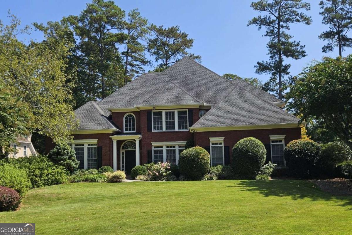 Rare four-sided brick beauty on a quiet cul-de-sac. This elegant and spacious home offers a low maintenance brick exterior, a level lot, and a highly sought-after primary suite on the main level - all tucked away on a peaceful street in the desirable Wheeler Magnet School district. Inside, you're greeted by a dramatic two-story foyer flanked by a large open dining room and a soaring two-story family room with a wall of windows and French doors that lead to the patio, fireplace with gas logs and more. The main level also includes a private home office with coffered ceilings, a separate laundry/mud room, and gorgeous real hardwood floors throughout. The oversized white kitchen is a chef's dream, featuring double ovens, a gas cooktop, a center island, pantry, and abundant cabinetry. It opens to a vaulted family room with a second fireplace and an adjoining breakfast room with access to the patio - perfect for entertaining. The main-level owner's suite boasts tall, coffered ceilings, two walk-in closets, dual vanities, a jetted soaking tub, separate shower, and private water closet. Upstairs, you'll find three generous bedrooms - one with an en suite bath, and two connected by a Jack-and-Jill bath - plus a large bonus room with a closet that could serve as a fifth bedroom, media room, or playroom. Architectural shingled roof features 6-inch gutters with leaf guards. Outside, the fenced backyard is a landscaper's dream, with a 5-zone irrigation system and a lush array of flowers, shrubs, and exotic trees. This home combines timeless design, abundant space, and an unbeatable location - all within a small, well-maintained neighborhood with an HOA that cares for the entrances.