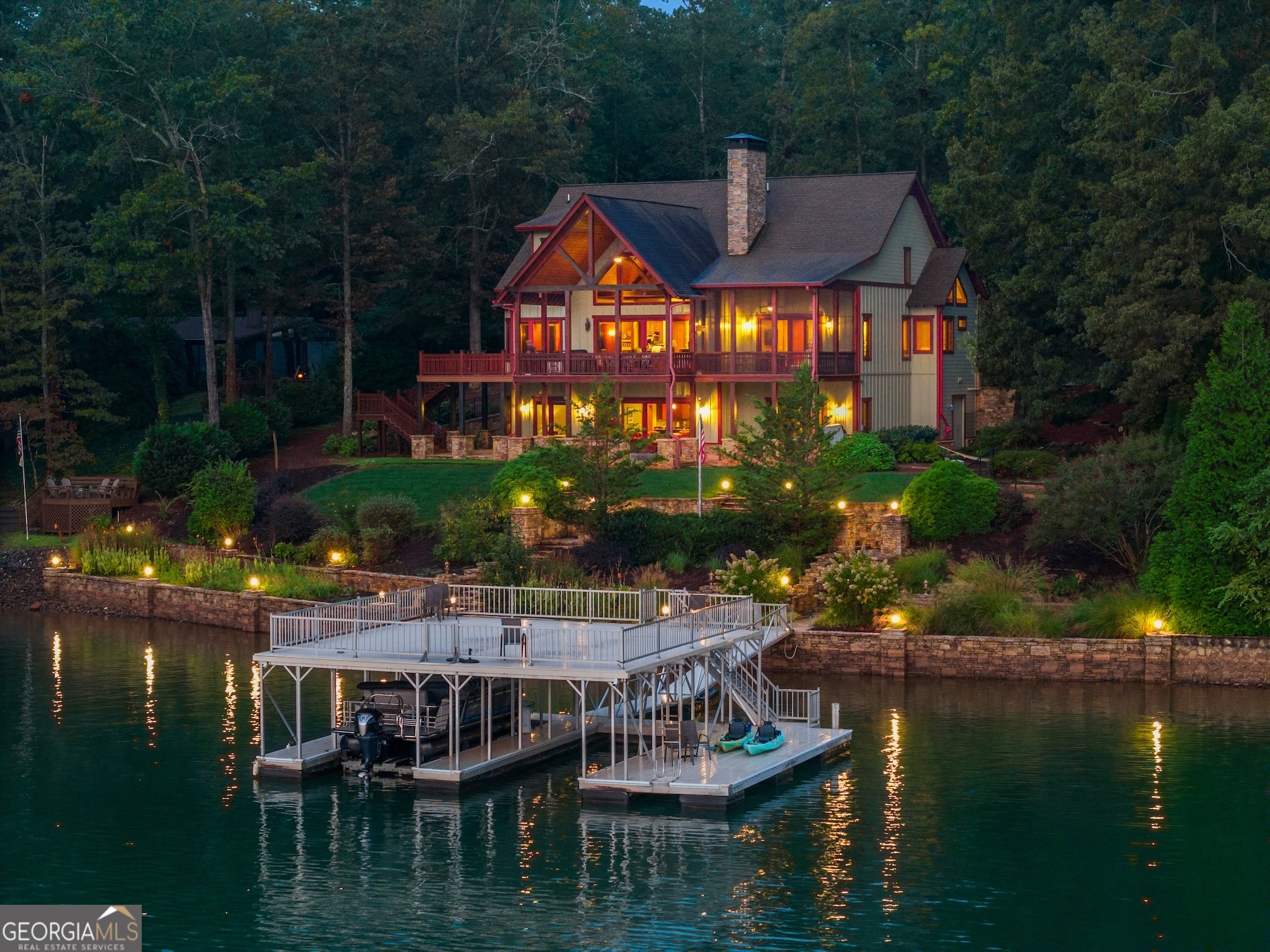One of Lake Chatuge's Finest with all the features that make a Great Lake Home. Deep Water, Expansive Mountain Views, Large Dock, Amazing Home. Discover lakefront living at its finest in this 5 bedroom, 5.5 bath custom Timberlake-built home on the pristine deep waters of Lake Chatuge, The Home offers breathtaking views of both the lake and Mountains. This masterpiece combines timeless craftsmanship, elegant design, and every luxury you could ask for in a Lake Home. Main Level Features: Spectacular Great Room with soaring ceilings, a dramatic stone fireplace, and massive windows framing unforgettable lake views Gourmet Kitchen with premium finishes, high-end appliances, and a seamless flow into the dining area overlooking the lake Stunning Master Suite with lake views, a private screened porch, spa-style bath, and walk-in closet Dedicated office and laundry/mud room Attached 2-car garage for easy access Upstairs Retreat: Private ensuite bedroom with full bath Additional bedroom and bath Loft area perfect for a lounge, library, or flex space Generous storage options throughout Terrace Level Entertaining: Two additional ensuite bedrooms with full baths Kitchenette/wet bar with refrigerator for hosting with ease Cozy den with a stone fireplace Workshop in Basement and plenty of organized storage Outdoor Paradise: Terraced stone walls & patios create multiple levels of outdoor enjoyment Expansive cathedral-covered screened porch and large open decks totaling thousands of sq. ft. of outdoor living space - all with incredible lake and mountain views Mature landscaping & irrigated yard to enhance the natural beauty of the lot Top-of-the-line aluminum Double Slip covered dock with swim platform & party deck on year-round deep water This home truly has it all: quality construction, abundant features, smart design, year-round water, and one of the best lakefront neighborhoods on Lake Chatuge. Home Comes Fully Furnished and includes Dock and Boatlift.