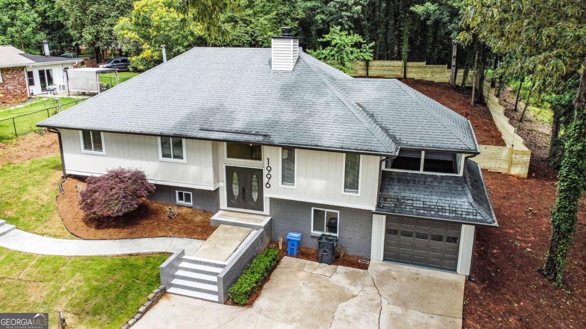 GORGEOUS, MODERN LAKE LANIER RENOVATION WITH 2 SEPARATE DRIVEWAYS FOR BOAT/RV STORAGE! The stately double front doors welcome you into the entryway where you can go up to the living room and kitchen area or downstairs to the fully finished basement. Off the living room you can relax or entertain on your screened in porch. Enjoy the Chef's kitchen surrounded by warm wood cabinets, a breakfast bar, quartz countertops, classic subway tile backsplash, and top of the line, smudge-proof, stainless steel appliance package including a French 4-door fridge. Relax in your primary bedroom retreat with a statement wall and a spacious closet with custom shelving. The ensuite primary bathroom showcases a tiled shower. Downstairs in the fully finished basement you'll find a family room, bedroom and full bathroom. Outside, discover the large, almost half acre lot with new spacious deck and private backyard with wood privacy fence perfect for entertaining, playing, or relaxing. Home is 10 minutes from vibrant downtown Gainesville Square, with many shopping and dining opportunities. This home also offers convenient access to I-985, the University of North Georgia, the Atlanta Botanical Garden, Gainesville campus, Lake Lanier, Olympic Park and Margaritaville featuring water parks and family fun.