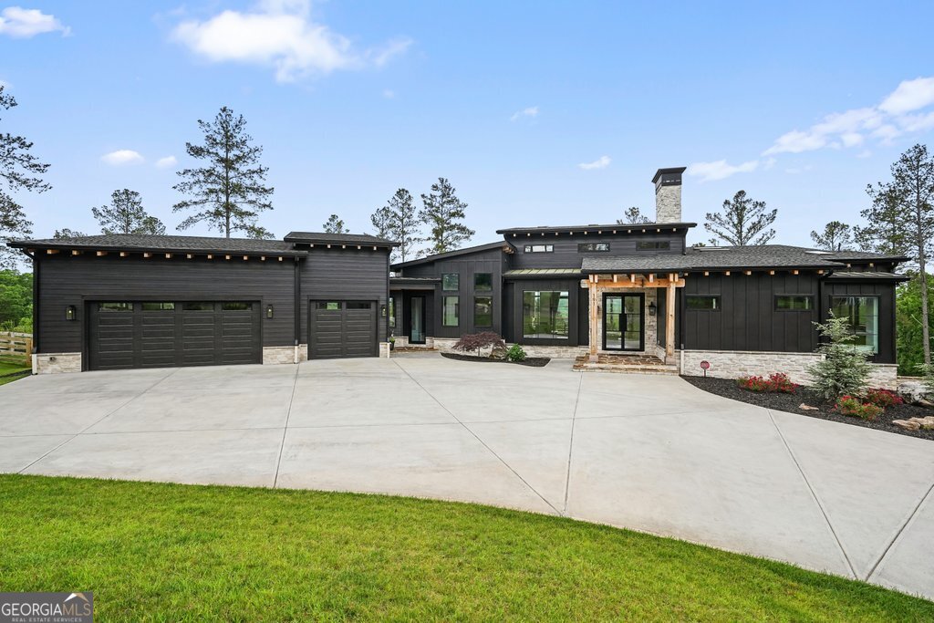 AMAZING NEW PRICE! - LISTED WELL UNDER RECENT APPRAISED VALUE! - Welcome to 191 High River Landing-an architecturally designed modern cabin that redefines mountain luxury. Nestled in an exclusive estate community and positioned to capture 20-mile layered views of the North Georgia mountains, this property blends clean, modern lines with natural materials and timeless sophistication. It's the kind of home that stops you in your tracks, not because it shouts for attention-but because it feels like it was always meant to be here. From the moment you arrive, the intention behind every design element becomes clear. This is not a spec build. This is a one-of-a-kind residence where no detail was left untouched. Built by the highly regarded Precision Custom Home Builders-one of North Georgia's premier luxury home builders-this home delivers quality craftsmanship and meticulous execution at every turn. The exterior design is a bold yet respectful nod to its mountain setting. Dark vertical siding, soaring rooflines, and expansive glass create a sleek contrast against the natural landscape. Step inside, and the drama only builds. Walls of oversized custom windows draw you into the view, flooding the home with natural light and erasing the boundaries between indoors and out. From sunrise to sunset, the home offers a front-row seat to nature's show. With over 3 private acres, the lot provides a level of privacy and serenity that's rare in today's market. And for buyers who desire even more space or long-term investment potential, the adjacent lot is also available for purchase depending on offer terms-creating an opportunity to expand your footprint in one of the most sought-after neighborhoods in the region. Inside, the home offers 4 bedrooms and 2.5 bathrooms, all laid out with thoughtful flow and functionality. The centerpiece of the home is the kitchen-a true culinary showcase anchored by a commercial-grade cooktop, high-end appliances, and sleek, modern cabinetry. Whether you're preparing meals for two or entertaining a full house, the space is designed to impress without sacrificing practicality. Luxury touches are everywhere, but they're never ostentatious. They're felt rather than flaunted-like the softness of premium flooring underfoot, the quiet close of custom cabinetry, or the seamless lines of fixtures and finishes selected for both their beauty and performance. Every room is a study in contrast-warm woods against cool stone, industrial design softened by the gentle play of light. The primary suite offers a peaceful retreat with soaring ceilings, panoramic windows, and spa-inspired finishes. Additional bedrooms provide flexibility for guests, work-from-home setups, or creative space, each with the same attention to design and function. This home isn't just built-it's curated. It's for the buyer who doesn't want what everyone else has. For the one who values design, quality, privacy, and the quiet confidence that comes from owning something truly exceptional. 191 High River Landing is a rare opportunity to own a one-of-one property in the heart of North Georgia. It's mountain modern reimagined, and it's ready for the next discerning owner to experience life at the top.