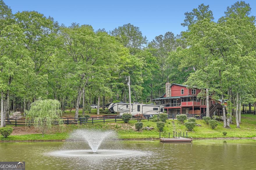 Stunning Lakefront Retreat on 6+ Acres - Private, Peaceful & Just Minutes from the City Welcome to your dream escape! This exceptional lakefront property offers over 6 acres of serene, scenic beauty-perfectly blending the charm of country living with the convenience of modern amenities. Located just 5 miles from I-20 and a short 22 mile drive to downtown Atlanta, you'll enjoy peaceful seclusion without sacrificing accessibility. As you arrive, you're greeted by circular drives, ample paved parking, and a wraparound porch that invites you to relax and take in the views. Whether you're entertaining guests, soaking in the jacuzzi hot tub, or just enjoying a quiet morning coffee, this home has it all. Inside, the two-story great room impresses with soaring ceilings, an abundance of natural light, and expansive views of the property's private, spring-fed lake-complete with fountain and dock. The open-concept layout flows effortlessly into the updated kitchen featuring granite countertops, modern appliances, and generous cabinetry, making everyday living and entertaining a breeze. A spacious loft overlooks the main living area and provides the perfect flex space for a home office, reading nook, or guest retreat. The home includes 4 well-sized bedrooms and 2.5 updated baths, with a finished basement offering even more living space-ideal for a media room, gym, playroom, or additional bedroom. Outdoor enthusiasts and hobby farmers will love the large garage/workshop, storage shed, and functional chicken coops already in place. The property is dotted with mature trees, flowering landscaping, and fenced areas ready for pets, livestock, or gardening. Enjoy life by the lake-fish off your private dock, host a sunset gathering, or simply take in the peaceful surroundings. With top-rated schools nearby and quick access to major roads, this is the perfect place to unwind, grow, and make memories. All that's missing is you. Schedule your private tour today and experience the magic of this one-of-a-kind lakefront retreat!