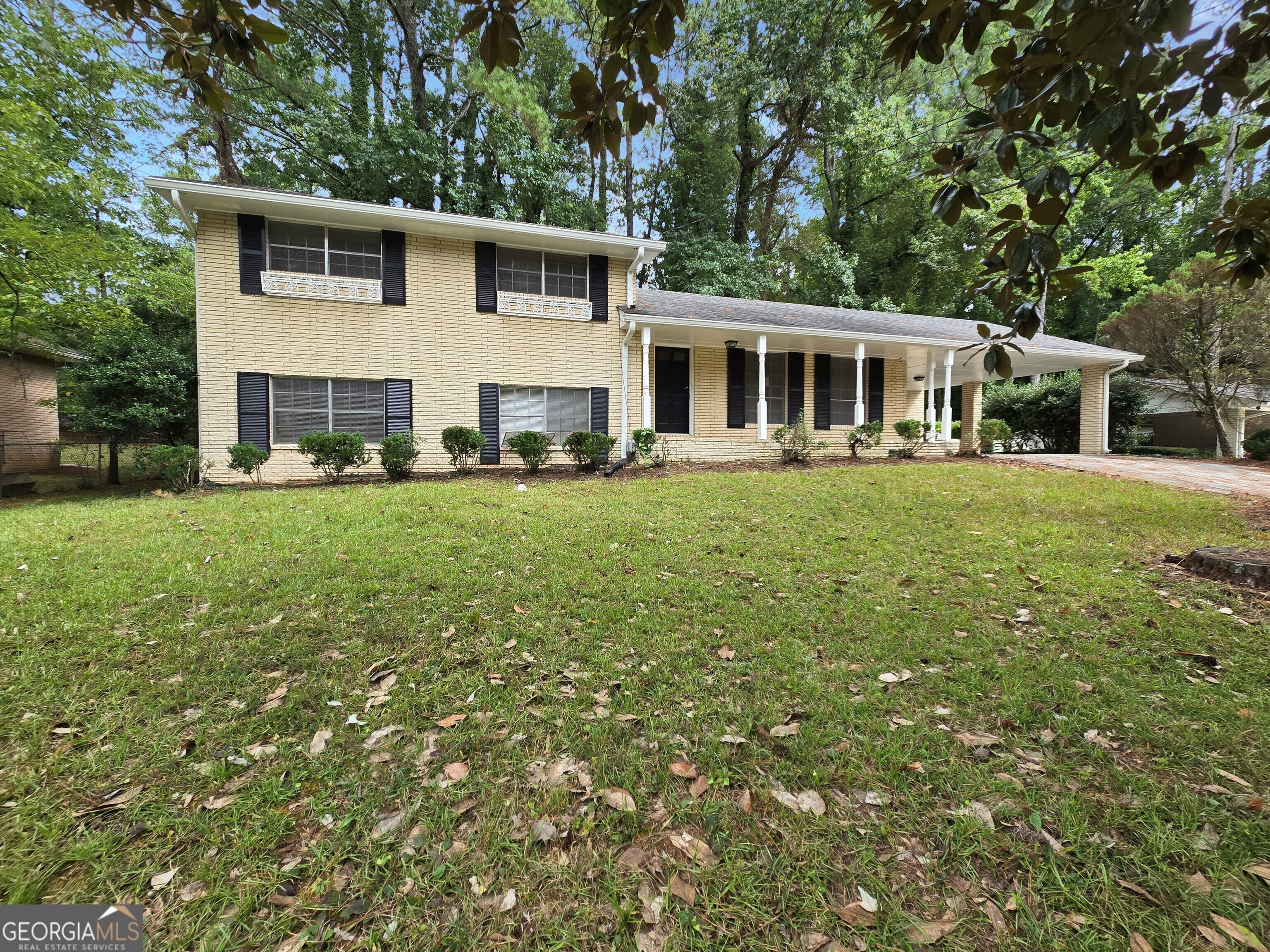 Come check out this amazing mid-century "style" home within minutes of Tyler Perry Studios, shopping, eateries, I-285, the airport, and downtown Atlanta. This 4-sided brick ranch sits on a large lot with mature hardwoods and landscape. The rocking chair front porch invites you to a large living room with beautiful hardwoods and plenty of natural light. A galley kitchen with wooden cabinets, an electric cooktop, and an oven, overlooks a separate dining room, perfect for entertaining friends and family. A sunken family room sits off the kitchen with exposed brick and a vaulted wooden ceiling with exposed beams. Head upstairs where the natural hardwoods continue throughout the three spacious bedrooms. There is a Jack-and-Jill bathroom with an updated vanity, flooring, and tiled bath. The lower level has been finished with an additional bedroom, bathroom, and a large bonus room, ideal for a recreation room, media room, or whatever your needs are. You will love the architecture of this home, the location, and all that the area offers. Don't let this opportunity pass you by. Come make this your home today!