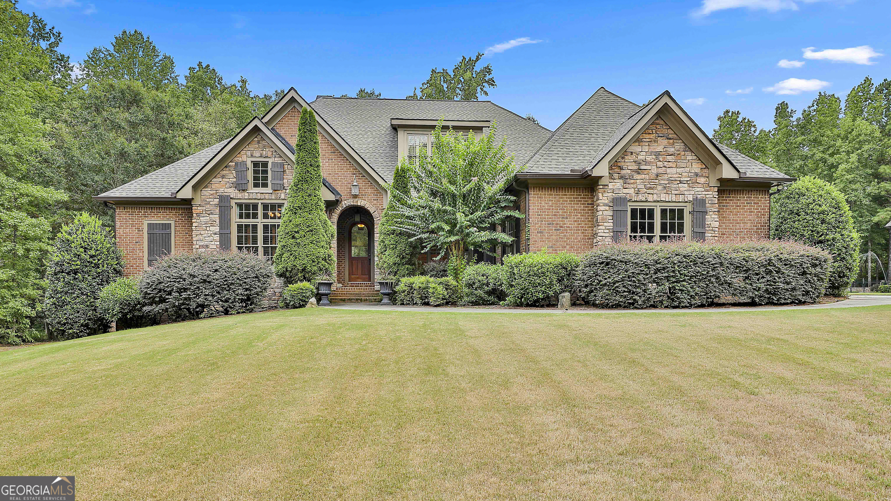 Welcome to this elegant and comfortable custom home in the prestigious Mountbrook subdivision! Nestled on a one-acre lot and connected to over 100 miles of Peachtree City golf cart paths, this home has space for everyone. The main level offers a stunning dining room with chandelier, separate living and family rooms with fireplace, a spectacular kitchen with breakfast area, a spacious primary suite with sitting area and deck access, plus a versatile secondary bedroom perfect for an office or nursery. Upstairs, you'll find three bedrooms, two baths, and a built-in desk area. The finished basement is open and inviting with a guest/teen/in-law suite, two full baths, direct access to the private backyard, and plenty of storage with room to expand. Additional highlights include plantation shutters throughout, custom curtains, new roof, new water heater, and new HVAC. A perfect home for entertaining, relaxing, and enjoying life in Peachtree City!