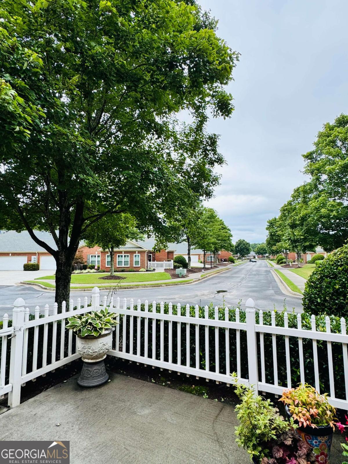 Introducing a rare chance to own a 2 bedroom / 2 bathroom ranch home in the most private / secluded spot in Buford's most sought after "Active 55+ Community", Friendship Corners! This beautifully constructed 4-sided brick ranch(condominium ownership)offers stepless, one-level living on a private cul-de-sac lot with side-driveway access to extended length, two-car garage parking. The garage features limo-depth parking, ample storage space on the sides and along the rear wall & a closet on the far right that houses the gas water heater, expansion tank, etc. The garage door is weather insulated and belt-driven, making it much quieter than chain driven garage doors. The overhead garage door opener is 3 years old & includes a remote for programming "HomeLink" garage door opening software found in most vehicles. This home is extraordinarily well kept and features a lovely open floor plan offering a large family room, complete with vaulted ceilings. At the center of it all is a very pretty, glass front, gas fireplace that is operated by a light switch on the wall next to it. A beautifully designed and built wood mantel surrounds the fireplace, making for a picturesque holiday photo setting. A very low use and very pretty "eggshell" colored carpet covers the floor in the living room, the dining room, both bedrooms & both closets & the hallway leading to the two bedrooms. The kitchen features a generous amount of counter space, quality wood-stained cabinetry that provides more than ample storage, a large, two-sided stainless steel sink with new hose & faucet sprayer combo unit & an eat-in breakfast bar just above that. The floor immediately inside of the front door features a 5 foot x 5 foot area of hardwood flooring. The primary suite has very large double walk-in closets, ample square footage, a ceiling fan, and 10 foot ceilings, etc. The primary bathroom features an over-sized walk-in shower and a double vanity / double sink configuration with increased height cabinets & countertops. The secondary bedroom enjoys plenty of natural light through double-paned, double windows. The second bedroom also features a ceiling fan / light that is activated by a wall switch. The secondary bathroom is ideal and offers a double vanity sink-countertop space, along with a very nice shower/tub combo in white with a shower curtain. Both bathrooms have extended mirror coverage above the sinks, proper lighting & exhaust fan in the ceiling. The outdoor living space gets an A + as it is the perfect patio space to relax in, entertain friends, neighbors and guests. This patio space is available for furniture, rocking chairs, umbrellas, tables, raised gardens, potted plants, flowers, bushes, etc. The relaxing private patio area alone looks out onto a gardened and purposefully landscaped wooded forest that is lush & beautiful. These wooded areas that the home looks out onto are as peaceful as they are private! The monthly HOA fees cover water, dwelling maintenance, termite bond, landscaping / lawn service, reserve fund, trash, sewer, pool access to the community swimming pool. Come and see why so many people have shared in the same positive and immediate reaction upon learning of this community and its stunning building designs, location and value. It is also within close proximity of the City of Braselton, Mall of Georgia, Sugarloaf Mills, Historic Buford, Treetop Quest Gwinnett, Lake Lanier, North Georgia Premium Outlets, highly rated dining & shopping. World class hospitals, trauma centers, ER's are all nearby as are the main expressways needed. ***The side-by-side washer and dryer units will convey to the buyer(s)at closing.***