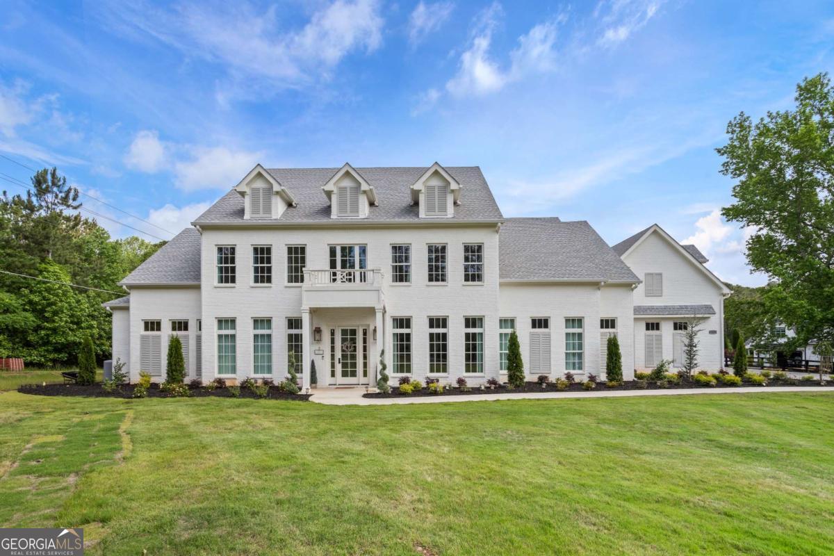 This newly built custom estate, completed in October 2023 offers approximately 6827 square feet of finely curated living space on over 1.6 acres at the corner of Redd and Freemanville. Designed with luxury and functionality in mind, the home features 5 spacious bedrooms, 5 full baths, and a half bath with the primary suite conveniently located on the main level. Step inside to discover engineered wood throughout and marble flooring in all bathrooms, soaring 10-foot ceiling on both levels, and expansive windows that flood the home with natural light and a gourmet kitchen highlighted by a custom plaster range hood crafted by a local Atlanta artisan. The kitchen is anchored by a 72-inch Sub-Zero refrigerator, double dishwashers, a convenient walk-in pantry and marble countertops throughout. Entertainment and comfort abound with a dedicated movie room, an oversized fitness room, multizone audio prewiring across seven interior zones plus outdoor areas and both upper and lower laundry setups for convenience. The master suite boasts a spa-inspired bathroom with dual-entry double shower, two shower heads. Outdoor living is elevated with 9-foot-wide fireplace, full property irrigation system. Additional highlights include extensive custom paneling, recessed and designer lighting throughout. Located in a coveted Milton enclave, this home is zoned for highly regarded schools. No HOA.