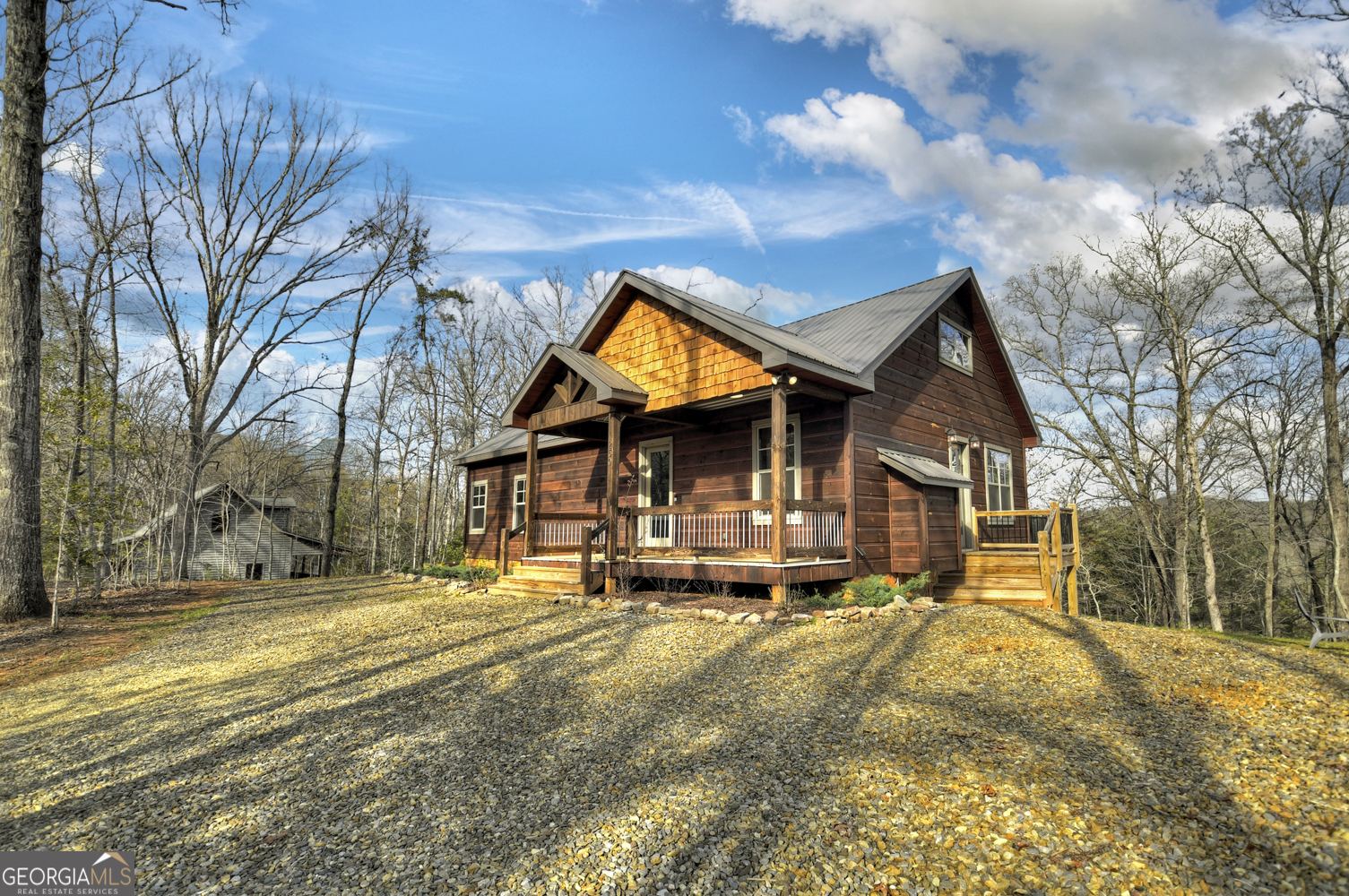 Your Dream Mountain Getaway...This stunning 4-bedroom, 4-bathroom home sits near the end of the road on 1.69 acres of serene, private land, surrounded by breathtaking mountain views. This quaint & quiet community is gated for ultimate privacy. On the main level, you'll find the spacious master with it's private en-suite bath in addition to a second bedroom with the luxury of it's own bath that can equally be shared with guests. Enjoy the spacious great room area filled with natural light and adorned by massive fireplace & a modern rustic blend kitchen perfect for entertaining. The upper level includes a large loft with oversize walk in closet and spa feel bath...private balcony to take in the view...perfect master, bunk room, or multi purpose area... Terrace level features its own living area with a large stone fireplace...perfect for rec room or den, along with guest bedroom and private bath. Enjoy outdoor living with access to large porch spaces on both the main and upper level. With a cozy firepit, ample room for outdoor activities, and a perfect blend of comfort and nature, this home is a true gem for those seeking tranquility in the mountains!