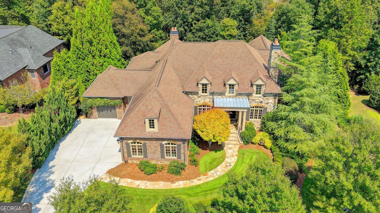 This exceptional one level estate offers a rare opportunity to experience refined living in an exclusive gated community. The home seamlessly blends classic design with modern convenience across 6,265 square feet of thoughtfully designed space. The primary suite is located on the main level and features a luxurious stepless walk-in shower and a cozy sitting area-perfect for unwinding with a book or enjoying morning coffee in peace. A full elevator provides effortless access to all levels of the home, adding both accessibility and sophistication. The chef's kitchen is a true centerpiece, boasting a massive island perfect for entertaining, top-of-the-line appliances, and a layout that invites culinary creativity. It opens gracefully to the family room, where a warm and welcoming fireplace creates the perfect setting for relaxation and connection. For added hospitality, the home includes two stylish bar areas-one upstairs and one downstairs-ideal for hosting guests or enjoying a quiet evening in. The expansive basement features a game room, recreation room, three additional en suite bedrooms, and a dedicated craft room, offering versatile space for relaxation and creativity. Outdoor living is equally impressive, with two covered porches, a spacious patio featuring a full outdoor kitchen, and a stunning infinity pool. The beautifully landscaped, year-round garden bursts with colorful foliage, creating a serene and vibrant retreat. A spacious three-car garage provides ample room for vehicles, storage, and hobbies, adding convenience and functionality to this already well-appointed home. Each room in the home offers a unique ambiance, and the expansive layout ensures every resident enjoys their own private sanctuary. This property is more than just a house-it's an invitation to embrace a life of comfort, style, and elevated living.