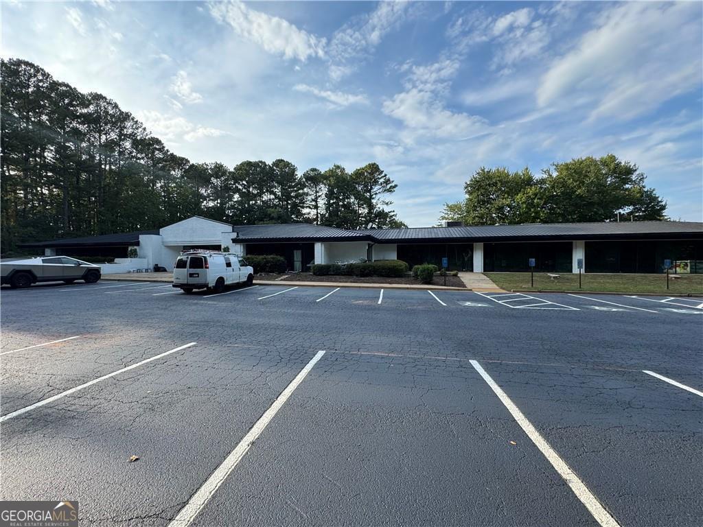 Located 5 minutes from Halcyon! Welcome to 5000 McGinnis Ferry, an impressive office building/warehouse situated on corner lot of McGinnis ferry and old Alpharetta rd. This is 21,000 sq ft building on almost 3 acres corner lot.  with ample space and unique details. This property includes spacious interior areas, allowing for flexible use and potential customization. Its outdoor space is expansive, providing opportunities for various outdoor activities or further redevelopment enhancement. The property is situated in a desirable windward business community with access to all amenities. Property is zoned industrial. The layout and structure emphasize both comfort and functionality, catering to a range of lifestyle needs. This property presents a distinctive and well-thought-redevelopment opportunity into shopping center or gas station.