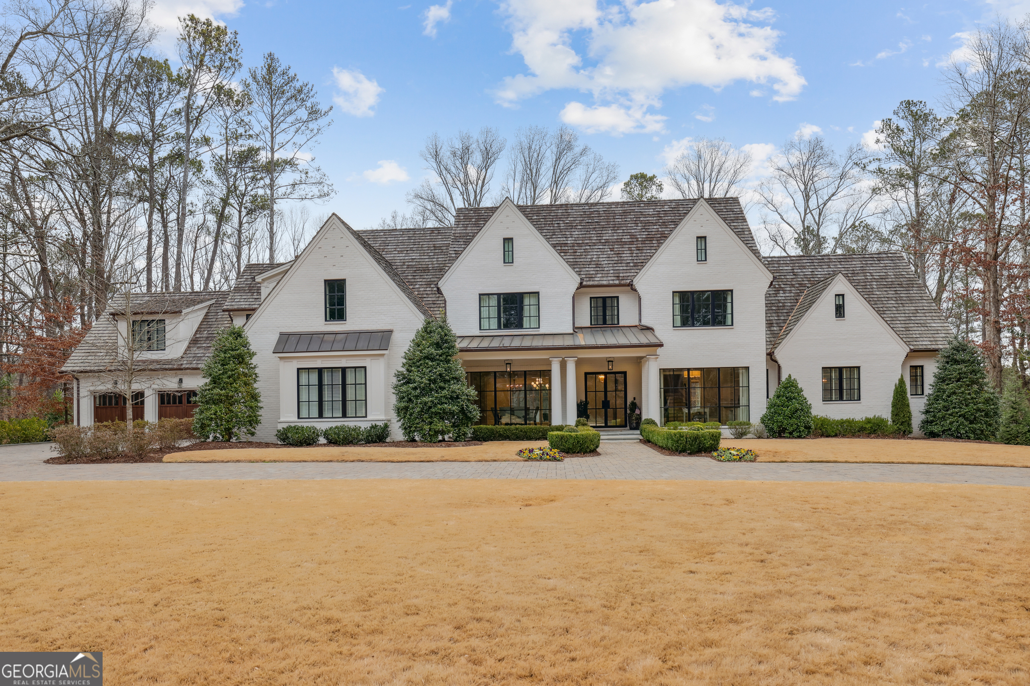 Stunning painted brick home with cedar shake roof and copper gutters. Primary on the main with elevator to three floors. A large open floor plan with folding glass walls/ accordion doors in the great room and keeping create a seamless indoor and outdoor living space with a motorized screen between the blue stone-covered porch and grill porch. There is another screened porch with a fireplace off the breakfast room. The chef's kitchen has marble countertops, custom cabinets, a walk-in pantry, Wolf/Subzero appliances, and a fireside-keeping room. The appliances include a steam oven, a dual fuel range with double ovens, a single wall oven, a Separate refrigerator and freezer, Built-in coffee, under-counter refrigerator drawers, Wine refrigerators, and an Ice machine. A Butler's pantry. The primary suite on the main has a morning bar, a luxurious primary bathroom with  heated floors, a double vanity, a soaking tub, a sizeable curb less entry shower, heated floors, two water closets with vanities, and two custom walk-in closets. Upstairs are five en-suite bedrooms with walk closets, a loft, and a Bonus/flex room. The recently completed terrace level has a fabulous bar with refrigerator drawers, Two wine refrigerators(125 Bottles a piece), a Dishwasher drawer, and an Ice maker. Large rec room and game room. Exercise room with cork floors, refrigerator of cold drinks, and towels. The terrace level leads onto a blue-covered patio and 18"X40' pool and spa. The entertaining continues with a large poolside TV for watching sports while relaxing in the pool or sitting by the rectangular fire pit. Other features include three laundries, a mudroom, front and rear stairs, foam insulation, a horseshoe driveway, a whole house generator, and walk-up attic stairs, to name a few.