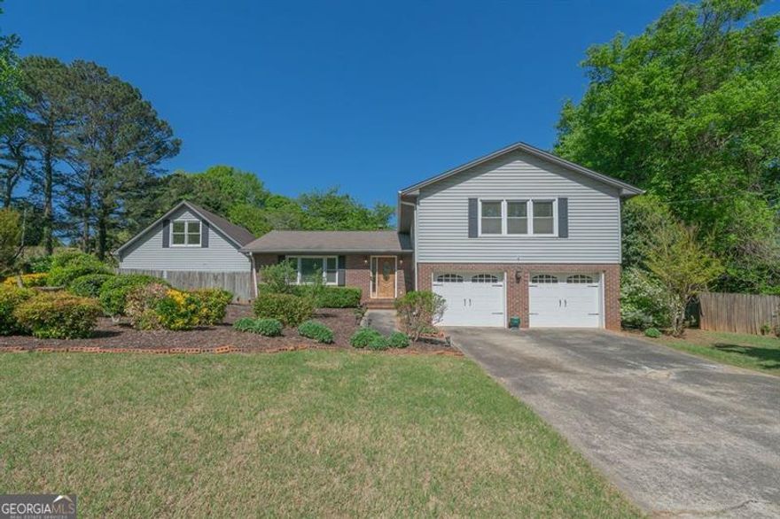 Time-Tested Charm Meets Modern Comfort in This 1973 Classic! Step into a groovy blast from the past-updated just enough to enjoy today's comforts while still honoring its original 1973 soul! Tucked into a beautifully landscaped lot bursting with flowering bushes and mature trees, this timeless two-story home is ready to write its next chapter with you. Inside, you'll find four generously sized upstairs bedrooms, including a primary suite that feels like a spa retreat-fully renovated with stylish, modern finishes that make it feel like you stepped into a design magazine and a second full bathroom! The main level is made for both memory-making and easy living, with a formal dining room for special occasions, a bright living room with large windows that bathe the space in natural light, and a cozy eat-in kitchen that overlooks one of the home's coolest vintage features: a sunken den straight out of a mid-century dream. Picture built-in bookshelves, a classic brick fireplace, and a nearby guest half-bath for convenience. Now, let's go back to this kitchen: Step into a kitchen that tells a story-with a perfect blend of timeless charm and thoughtful updates. The vintage wood cabinetry brings a sense of warmth and nostalgia, while the gleaming granite countertops and hand-inlaid ceramic tile backsplash add just the right touch of modern elegance. The hardwood floors shine with pride, reflecting years of care, and the rich, stained wood trim adds a cozy, grounded feel that today's homes often miss. This is more than a place to cook-it's a space that invites conversation, memory-making, and slow mornings with coffee and sunlight pouring through the windows. It's the kind of kitchen that feels like home the moment you walk in. Off the den, step into the sunny tiled sunroom with panoramic views of your lush backyard oasis. Slide open the door to discover a terra cotta patio-the perfect place for morning coffee or relaxing with a good book. But wait, there's more: The attached two-car garage sits just in front of the den, and the backyard boasts a second detached two-car garage, complete with a workshop and an upstairs loft-ideal for storage, hobbies, or that dream studio you've been wanting. This home offers the best of both worlds: nostalgic character and craftsmanship with a touch of modern updates, and outdoor beauty that just keeps blooming. What about the setting? Piedmont Hills is an iconic subdivision, located steps from the Bells Ferry Trail Head at Noonday Creek and a short drive to everything Barrett Pkwy has to offer. Come see this special gem before it's gone! PLEASE NOTE: This home is not updated to today's finishes except for the primary bathroom, so please expect vintage finishes and design. Home is being sold as-is. Home appraised in Oct 2024 for $450K as it sits.