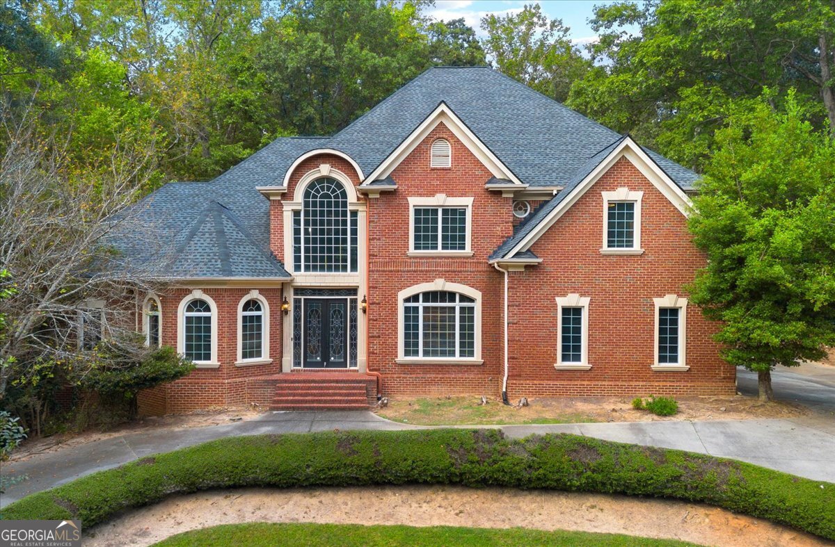Experience timeless sophistication at 1670 Riverside Road, an extraordinary 9,251 sq ft private estate in the coveted, tree-lined enclave of Roswell, Georgia. Set behind a sweeping driveway and framed by picturesque views, this architectural masterpiece welcomes you with a grand foyer and dramatic curved staircase, unfolding into sun-drenched living spaces with floor-to-ceiling windows and bespoke cabinetry throughout. The owner's suite on the main level is a sanctuary of indulgence, showcasing a spa-inspired bath, oversized boutique closet, and discreet main-level laundry. Curated for exceptional entertaining, the home features keeping and breakfast rooms, a butler's pantry, and a chef's scullery. A fully finished lower level reveals a world-class theater, sauna, full kitchen, and elegant living lounge-perfect for hosting or private retreats. Outdoors, an airy resort-style oasis awaits, anchored by a shimmering pool and generous terraces ideal for alfresco gatherings. A three-car garage completes the estate, which is powered by gas and electric utilities and enriched by an executive study for distinguished work-from-home living. With no HOA and moments from premier country and swim/tennis clubs-The River Club, Roswell Country Club, and Horseshoe Bend Country Club-this residence blends unparalleled privacy with effortless access to the best of North Fulton. Offered at fair market value, 1670 Riverside Road is a statement of artistry, comfort, and enduring luxury.