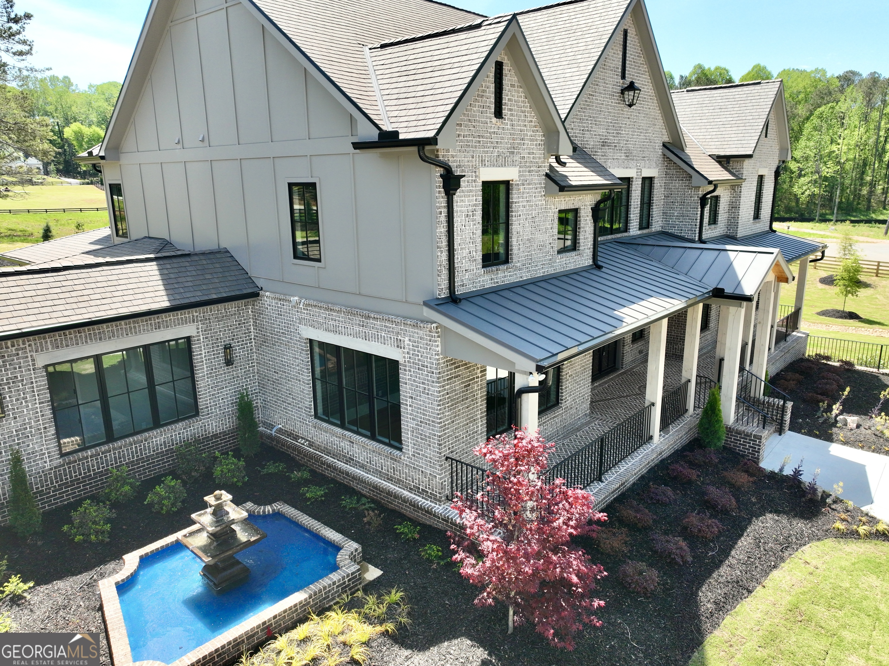 Welcome to an extraordinary expression of craftsmanship and modern luxury. As you arrive via one of two stately driveways, you're greeted by grand columns crowned with glowing gas lanterns, an elegant prelude to the refined living experience that lies beyond. Expertly crafted with uncompromising attention to detail, this brand-new construction home blends timeless architectural beauty with cutting-edge technology and enduring materials. Every inch of this stunning Craftsman-style residence has been thoughtfully designed to elevate everyday living into an experience of elegance and ease. Set in the heart of Alpharetta's prestigious Cherokee County, this home is a rare find, combining the charm of suburban serenity with the convenience of nearby top-rated schools (Avery, Creekland, Creekview, and The Haven Academy), premier shopping, fine dining, and expansive parks. Striking brick construction lends warmth and stature to the exterior. Inside, rich stain-in-place hardwoods span the home, paired with handcrafted custom cabinetry and high performance concrete countertops with built-in sinks. The chef's kitchen and outdoor culinary space feature elite Wolf and Sub-Zero appliances perfect for entertaining or quiet evenings at home. An expansive 1,000-square foot covered patio with herringbone brickwork, built-in heaters, and gracious open air living invites you to relax and unwind year-round. The primary suite offers a spa-like escape with heated tile flooring and a professionally designed, boutique style master closet. This smart home is prewired for EV charging and offers full mobile control of HVAC, lighting, surround sound, and Lutron window shades bringing convenience to your fingertips. The F-Wave premium synthetic roof, with a lifetime warranty, offers protection against 130+ mph winds, Class 4 hail, and Class A fire. Jeldwen Casement windows come with a 10 year frame and 20 year glass warranty. Nearly 10,000 square feet under roof, including garage and covered porches. Backyard approved for a future in-ground pool. Located within a private enclave of just 7 expertly curated new homes (lots not sold individually). Showings are available with Proof of Funds or a Pre-Qualification Letter. Listing agent will accompany all showings to provide personalized insights into this impeccable home. Schedule your showing today and ask me about our creative financing options!