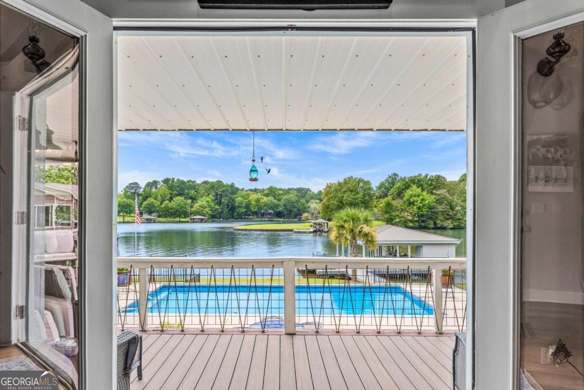 THE ULTIMATE ONE -OF-A-KIND-LAKE HOME! INCREDIBLE VIEWS, SALTWATER POOL, GUEST COTTAGE AND BEST PORCHES ON THE LAKE! This property screams "FAMILY AND FRIENDS" and can SLEEP 16 COMFORTABLY. Red iron supported steel exterior framing with hardy board siding makes this a structural force to be reckoned with! The main home has 2 PRIMARY SUITES on the MAIN LEVEL plus a 3rd bedroom and a huge OPEN LOFT designed with both play space and sleeping space. Open kitchen plan with quartz and custom quality hickory cabinets- vaulted family room w/hardwood flooring. 2nd pantry with extra storage in laundry room. Ice maker conveys to keep the drinks ice cold! Detached DOUBLE GARAGE with charming upper 1 BR 1 BA COTTAGE with full kitchen and laundry! So cute... and the views from the cottage are the BEST! Outdoor living is unmatched here: the street-side party porch (25x50) is the go-to gathering spot for family cookouts, reunions and corn hole while the lake-side porch (10x50) spans the home, overlooking the saltwater pool and level lot. Stocked Koi pond. DOUBLE BOATHOUSE will knock your socks off! Small man cave outbuilding is an extra bonus. Great WATER FRONTAGE, great VIEW, great LOCATION and all the makings for the perfect family gathering place! Closing must take place Nov. 9 or after. Fee simple.