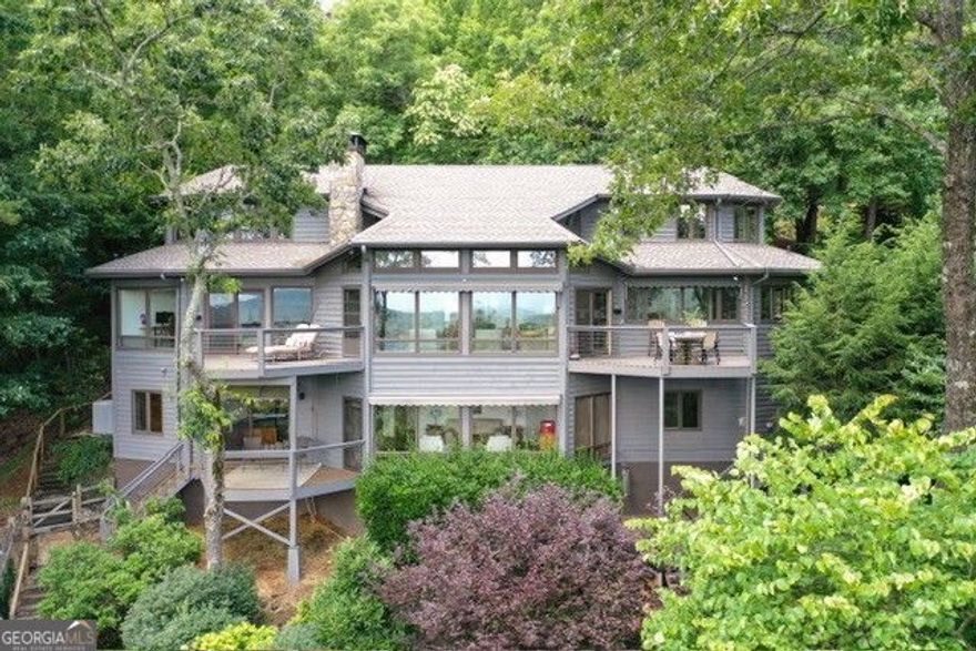 This is the GA mountain retreat you have been looking for!  It is a spectacular custom Home nestled in the mountains of Big Canoe.  Enjoy short and long views as far as the Atlanta Skyline.  Artist/Architect designed, this home with its open floor plan, seamlessly integrates nature into every corner.  Antique pegged wide-pine floors, exposed beams, and abundant windows create a bright and inviting atmosphere.  Step outside to admire the beautiful gardens and pet-friendly yard, complete with several private patio areas perfect for outdoor entertaining.  Remote control awnings over the living room windows ensure optimal outdoor exposure.  Too many special features to mention.  You must see it to appreciate the craftmanship.  Welcome to your new mountain retreat with a private view from 'every' angle. Welcome to North Georgia and the southern point of the Appalachian Trail.