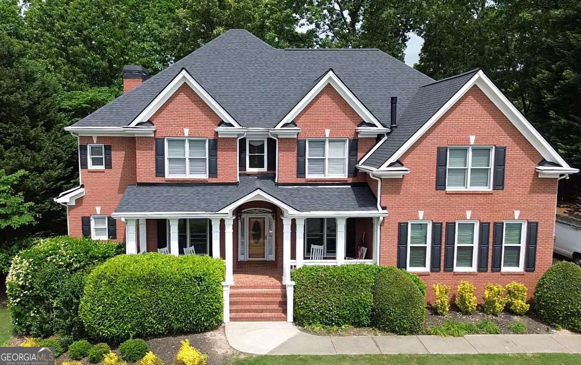 Welcome to this stunning former builder?s model?an elegant, four-sides-brick executive home offering over 6,200 sq ft of thoughtfully designed living space. Featuring a brand-new roof and a 3-car side-entry garage, this home is nestled in a highly sought-after neighborhood.You?ll be charmed by the inviting covered front porch and dramatic entryway, which features both front and rear staircases, along with an open, light-filled floorplan.With 6 spacious bedrooms and 5.5 baths, there?s room for everyone?including a convenient main-level guest suite with a private bath. The formal dining room, accented with elegant wainscoting, the formal living room, and the oversized great room with built-ins, a fireplace, soaring twostory ceiling, and a dramatic wall of windows all create the perfect setting for both entertaining and relaxing.The gourmet kitchen is a chef?s dream, offering solid surface countertops, a tile backsplash, rich stained wood cabinets, an island with gas cooktop, double ovens, a large eat-in area, a walk-in pantry, and an extra-large laundry room just off the kitchen for added convenience. Step out onto the back deck and enjoy the private, landscaped backyard?ideal for relaxing or hosting.Upstairs, unwind in the oversized primary suite featuring double tray ceilings, a cozy sitting area with fireplace, and THREE generous closets. The spa-like en-suite bath includes separate his-and-hers vanities, a soaking tub, and a separate shower. Two additional bedrooms complete the upper level?one with a private en-suite bath and another served by a large hall bath. A unique upstairs library wall overlooks the great room, adding architectural interest and charm.The professionally finished basement is perfect for entertaining or multigenerational living. It includes a bedroom, full bath, theater room, rec room with fireplace, home gym, and generous storage space.All this in a prime location with easy access to I-985, I-85, Hwy 316, and just moments from shopping, dining, and entertainment.