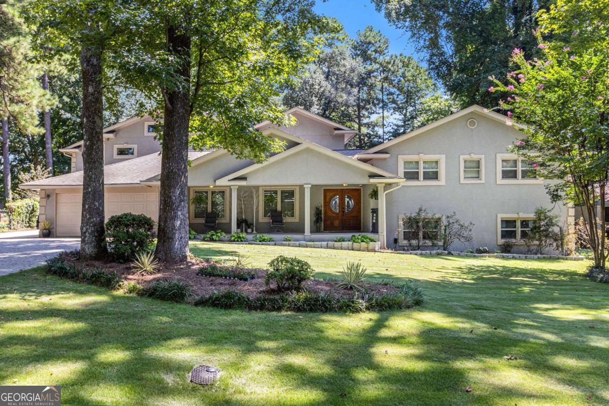 This is not a cookie-cutter traditional or trendy contemporary-it's more. More room to celebrate, entertain, and retreat. Set on a deep, wide lot at the end of a hand-laid stone driveway, this property offers two homes, a private pool oasis, and versatile spaces inside and out. Enjoy poolside living with expansive decking, private green space, a 4-car garage plus workshop, and 2 hidden extra parking spots. Unlike most new builds, this home is thoughtfully set back with exceptional privacy. The Main Home opens with a covered porch and elegant solid wood doors. Inside, light floods through soaring windows, showcasing gleaming hardwoods and soft architectural corners. The formal dining room and large island (seats 8) offer flexible entertaining options. The kitchen features stone countertops, wall-to-wall cabinetry, integrated appliances, and a walk-in pantry. Off the kitchen, a bright solarium with half-bath opens directly to the pool deck. Also on the main floor: a laundry room with storage, 2-car garage, tandem 2-car garage, and a workshop nearly the same size. Up five steps is the luxurious Owner's Suite with sitting area, private balcony, spa-like bath with soaking tub and double shower, and two walk-in closets-one the size of a bedroom. A second bedroom with full bath is also on this level. Down five steps: a home office and a sprawling entertainment level with pool table, bar, projector, multiple TVs, and access to the pool. Back to the Main Floor is a lobby with side entrance, half-bath, split staircase, and elevator to all three floors. Upstairs is a complete guest or family suite with living/dining area, kitchenette, and three oversized en suites - one with a balcony overlooking the pool. The lower level is built for celebration, wrapped in a retro 80s vibe with a full party space, spa, sauna, salon, and massage area. The showstopper is the gunite pool with waterfall hot tub, glowing at night amid lush surroundings and generous lounge space. The backyard is wide enough for both pool and play in an additional grassed space the size of another yard. This isn't just a home, it's a private retreat built for living, hosting, and enjoying. A true Showcase Home not to be missed.