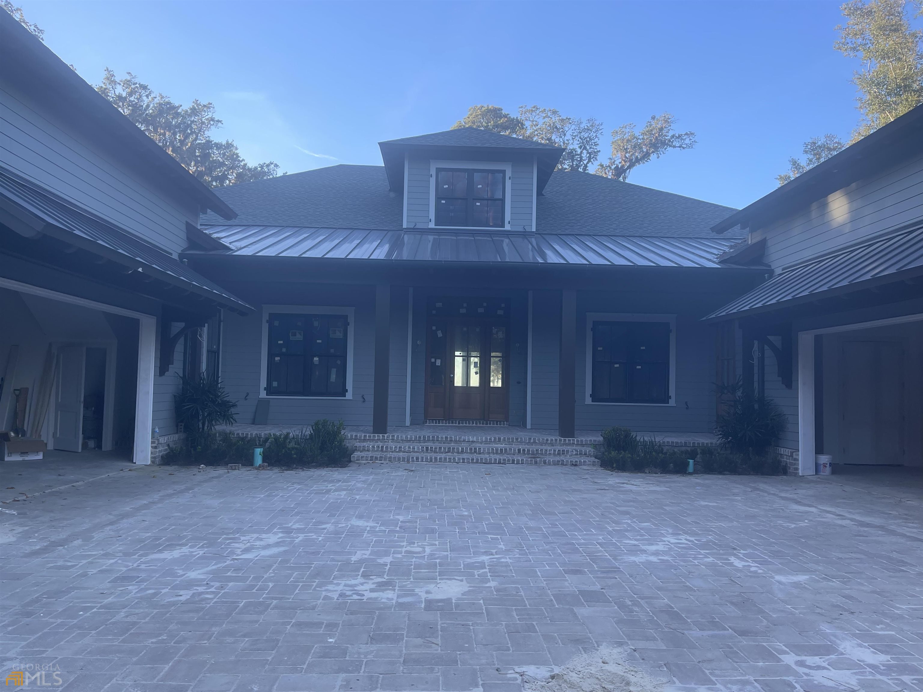 This beautiful craftsman style home with high quality finishes, featuring 5 bedrooms and 6 and a half baths, meets all the criteria for luxurious island style living. This well-built home is located in the private gated community of Kings Point. Currently under construction, the home willl be completed in January 2023. Located on the East side of the neighborhood, the home sits on 1.2 acres with an amazing view of the St. Simons Sound along with stunning marsh views. Designed by architect Kevin Higgins and custom built by 3181 Construction (Hank Rowland and Scott Cochran). Beamed ceilings and understated wood flooring set the mood for an open concept with beautiful coastal views from almost every room. Wolf and Subzero appliances are the perfect combination for a chef's kitchen which overlooks the warm and inviting great room with custom trim, beams and space for your largest big screen TV. The main floor primary suite in this home includes a fabulous view from every angle and a huge primary bath with beautiful tile, an amazing large shower, separate soaking tub, and his and her custom closets. Separate office or library with built in bookcases and family room are on the main level. Three more bedrooms with private baths and one powder room. A fifth bedroom or game room with a full bath is on the second level along with walk in closet. A home gym or home theatre are located on the opposing side of the home on the second level. Pool side covered porch, pool and pool house with large bath enhance the back yard overlooking the marsh and river and ensure that guests will be entertained and comfortable. Spectacular outdoor kitchen in large porch, fully enclosed with drop down screens. This home is a truly one that a buyer will not want to miss if looking for prime location, prime views and prime quality in a home. Square footage - 5985 and an additional 2413 sq feet of porches and garage.