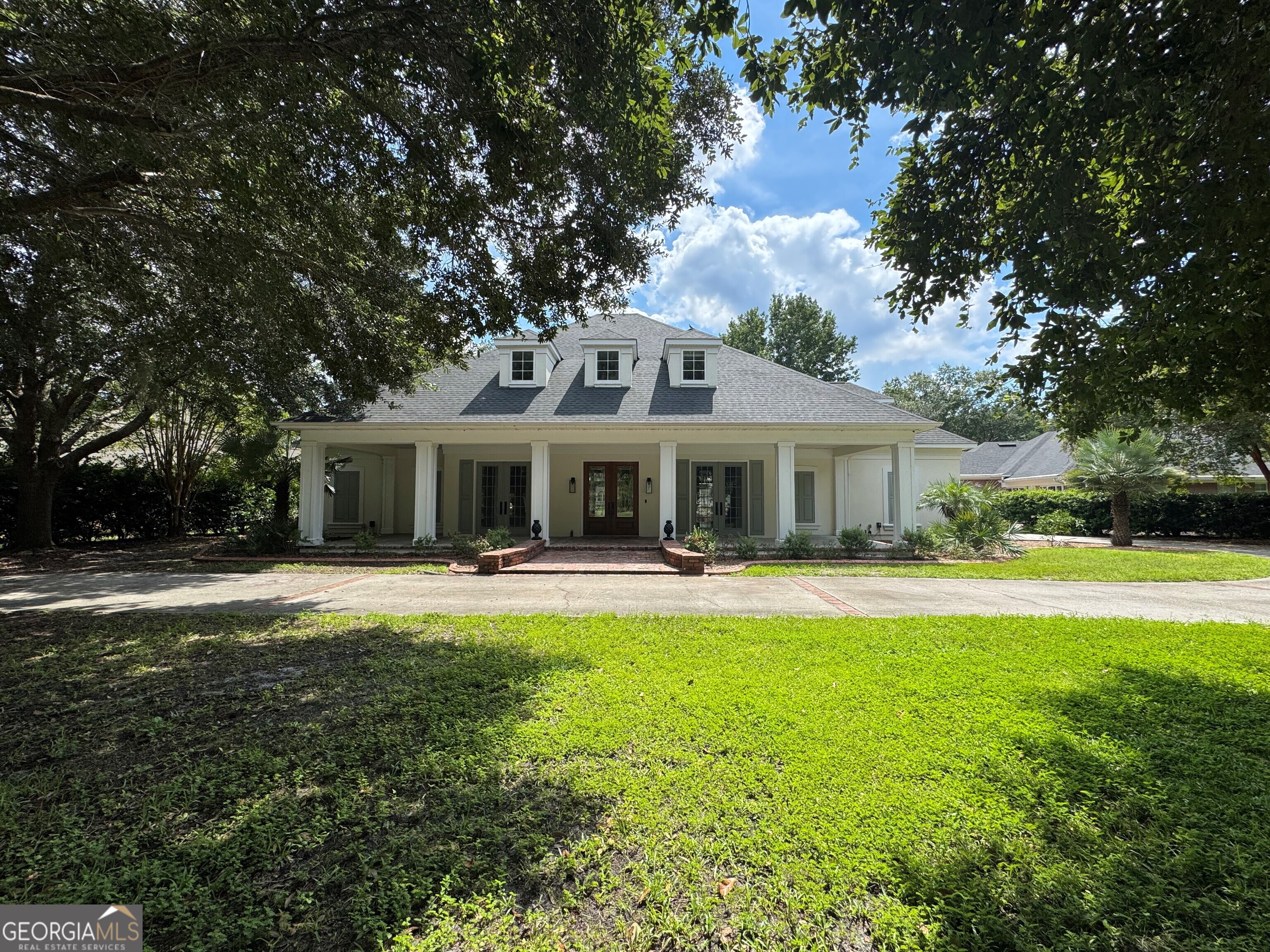 ****NEW ROOF*** PRICED TO SELL! Nestled within the exclusive, 24/7 guard gated community of Osprey Cove, this exquisite custom-built residence by W.H. Gross Construction offers unparalleled craftsmanship and timeless elegance. Set on a serene .69-acre lot, this home is enveloped by majestic oak trees that create a canopy of shade, enhancing the tranquil ambiance of the property while providing stunning views of the shimmering lake. As you approach, a charming brick-paver rocking chair porch greets you, perfectly framed by the stately oaks and a circular driveway that leads to a side-entry two-car garage. The open, airy interior boasts soaring ceilings and crown molding throughout, amplifying the grandeur of the space. With four generously-sized bedrooms, two and a half bathrooms, and a dedicated office, this home offers ample room for both work and relaxation. The primary suite, conveniently located on the main level, serves as a true retreat, featuring slate-tiled floors, while the remaining upstairs bedrooms are carpeted for added comfort. A chef's dream, the kitchen is adorned with premium quartz countertops, stainless steel appliances, a gas cooktop, recessed lighting, and a spacious pantry for all your culinary needs. The inviting family room seamlessly flows into the screened-in brick lanai, offering breathtaking views of your private backyard oasis. This home has been meticulously updated with top-of-the-line features, including a new hot tub, smart garage door opener, smart irrigation system, garage shelving, and wainscoting. Significant improvements were also made in 2022, including a new HVAC system, water heater, water softener, filtration system, as well as fresh paint, updated hardware, and new fixtures throughout. The exterior has also been enhanced with new landscaping, a stylish privacy fence, and elegant outdoor lighting. Beyond the home itself, this property offers the convenience of being within walking distance to the River Club and Pool (separate membership required), with no flood insurance required. With a range of luxury finishes, exceptional attention to detail, and a prime location, this home is truly a must-see. Priced competitively and with motivated sellers, this is an opportunity that should not be missed!