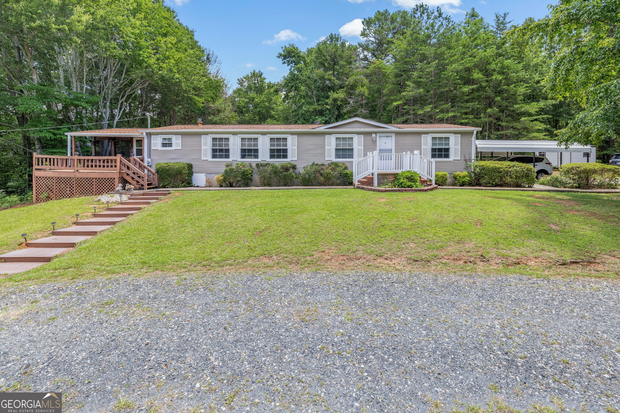 Escape to the tranquility of country living with this beautifully maintained manufactured home situated on just over 11 acres of private land, only minutes from Lake Hartwell. This spacious home features a split bedroom layout with three bedrooms and two full bathrooms, a large kitchen with a center island and breakfast area, and a dedicated mudroom/laundry for added convenience. Primary bedroom ensuite bath has soaking tub, separate shower, and his and hers closets. Enjoy the outdoors from multiple spaces including a welcoming front porch, two decks, and a large screened-in porch, ideal for relaxing or entertaining. The property is well-equipped for a variety of uses with approximately eight acres of fenced and cross-fenced pasture, a stream flowing through both fenced areas, and a holding pen-making it perfect for livestock or hobby farming. Additional improvements include a four-stall pole barn with electricity, a detached garage/workshop with water and electric, and an outbuilding with power. Covered RV parking with water and electrical hookups and two detached carports offer ample room for vehicles and equipment. Offering the rare combination of peaceful seclusion with close proximity to recreational opportunities on Lake Hartwell, this property is ideal as a full-time residence, mini farm, or country retreat.