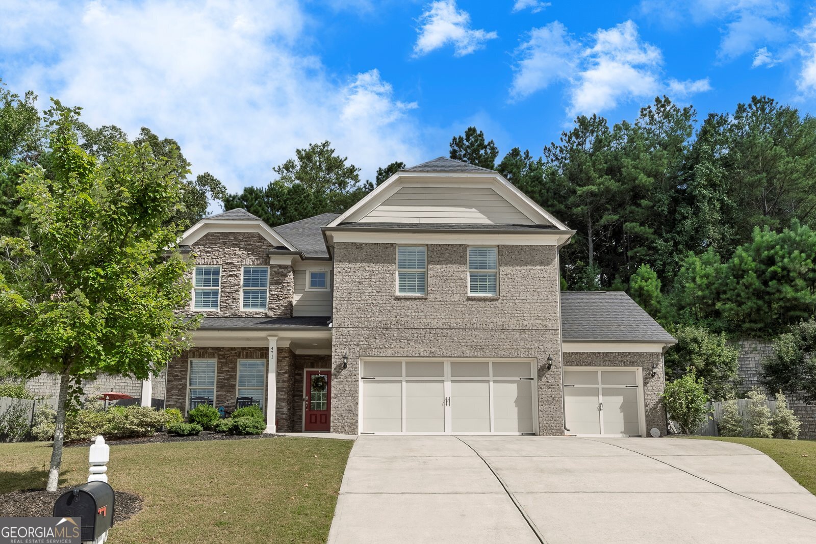 Tucked away on a peaceful cul-de-sac in one of Cherokee County's most sought-after communities, this stunning 4-bedroom, 3.5-bath retreat in Woodmont offers a luxurious blend of comfort and resort-style living on over half an acre of meticulously landscaped grounds. Step inside to an open, light-filled layout where soft grey tones, custom designer lighting, and warm hardwood floors create an inviting, sophisticated ambiance. The gourmet kitchen is a chef's dream, featuring dove grey cabinetry, gleaming white quartz countertops, stainless steel KitchenAid appliances, a convection oven/microwave, under-cabinet lighting, and a massive island that flows effortlessly into a cozy family room with a dramatic floor-to-ceiling stacked stone fireplace. Enjoy the flexibility of two spacious master suites-one on the main level with a spa-like ensuite bath showcasing a glass-enclosed rain shower and bench, and another upstairs with dual walk-in closets and a serene en-suite bath. Every upstairs bedroom offers generous walk-in closets and surrounds a central loft/game room area with an additional full bath and abundant storage. French doors lead to a versatile flex room perfect for a home office or formal dining, while a built-in planning center off the kitchen adds even more functionality. Step outside and feel the serenity wash over you in the private backyard oasis, where a covered lanai with built-in Klipsch outdoor speakers overlooks a heated 14' x 30' saltwater pool featuring a stacked stone waterfall, underwater bench, and tanning ledge-ideal for entertaining or unwinding under the stars. With hookup for a gas grill, automatic pool vacuum, and thoughtful upgrades, every detail has been curated for ease and enjoyment. A spacious 3-car garage and ample storage complete the home, while community amenities include pools, tennis, pickleball, a playground, clubhouse dining, and optional golf memberships at the Robert Trent Jones Jr.-designed championship course. Located near top-rated schools, shopping, and dining, this exquisite home truly offers the best of refined, easy living. This home won't be available for long... schedule your showing today!!