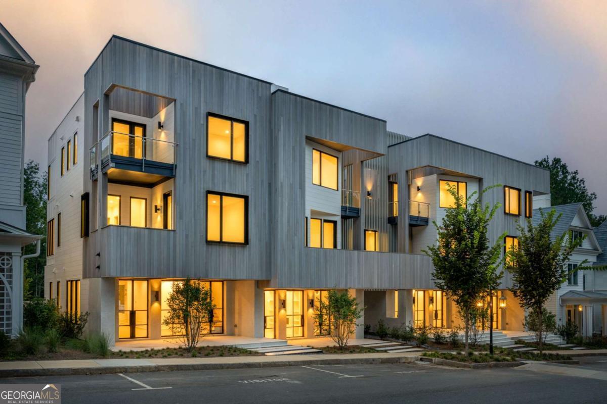 Nestled in the Overlook Hamlet of Serenbe, these modern townhomes epitomize luxury and comfort with their thoughtfully designed open floor plans. The living and dining areas seamlessly blend to create a spacious and inviting atmosphere, ideal for both everyday living and entertaining. Each townhome boasts a charming front porch, perfect for relaxing and enjoying the serene surroundings. The primary suite, located on the second level, offers a private balcony, providing a tranquil retreat with stunning views. Additionally, two versatile flex rooms with their own balcony overlooks the treetops, offering a peaceful space for a home office, studio, or additional lounging area. The townhomes also feature en-suite bathrooms for each of the three guest bedrooms, located on the third floor, ensuring privacy and convenience for guests alike. This home also includes an added-in elevator, convenient for every day living. Overlook is Serenbe's newest pocket neighborhood, featuring immediate access to over 20 miles of soft surfaced nature trails with protected forest views + a short distance to every Serenbe wellness amenity. ? DISCLAIMER: Some photos in this listing have been virtually staged or digitally rendered to illustrate the potential of the home's interior and exterior spaces. These images are for visualization purposes only and may not reflect the property's current condition or features.