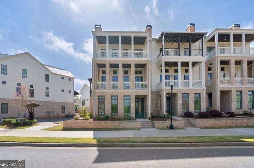 Welcome Home to 2029 Heritage Walk in the heart of Downtown Milton.  From the moment you step inside, you know you are about to experience luxury on a whole new level. This rare 4 bedroom end unit is truly steps away from all the downtown Crabapple area has to offer. The first level features two generously sized secondary bedrooms and a full bath. Make your way upstairs and be prepared to be amazed. You are greeted with 12 foot ceilings on every level, floor to ceiling windows, and all of the luxurious finishes you would expect to find. Better than new construction and impeccably maintained, this home offers the scale and comfort of a single-family residence with the ease of townhome living. Natural light floods each level and accentuates the beautiful wood features and luxury plank vinyl floors throughout. The kitchen is an absolute entertainer's dream with Viking appliances, warming drawer, stunning quartz counters, custom cabinetry, two refrigerators, motorized window treatments and a fabulous walk-in pantry. Enjoy outdoor living at its finest with amazing views from multiple private patios on every level, including the unforgettable rooftop terrace that overlooks the Crabapple Green-where you can witness glowing sunsets and starry nights. The primary suite is nothing short of indulgent-your personal retreat features a luxurious soaking tub, incredible walk in shower, custom motorized window treatments for effortless light control and privacy a spacious walk-in shower, and a dream-worthy custom closet that's both oversized and expertly tailored for style and function.  Throughout the home, you'll find designer finishes, upgraded lighting, engineered hardwood flooring, and timeless architectural touches. Enjoy other luxurious features such as a private elevator that offers ease and convenience accessing three levels, spacious secondary bedrooms, ample closet and storage space, electric car charger, tankless water heater, and so much more. This home isn't just beautiful-it's turnkey, low-maintenance, and truly one of a kind. Whether you're sipping coffee on the rooftop terrace, hosting guests on the main floor, or strolling to dinner down the street, life here feels as exceptional as the home itself. Nestled in the heart of Crabapple, you are perfectly positioned just steps away from the town's charming boutiques, fine dining, weekend farmer's markets, and outdoor concerts. The HOA covers roof, termite, trash, additional parking area, and you can enjoy the shared amenities of the Braeburn community. This is definitely the one to call home.